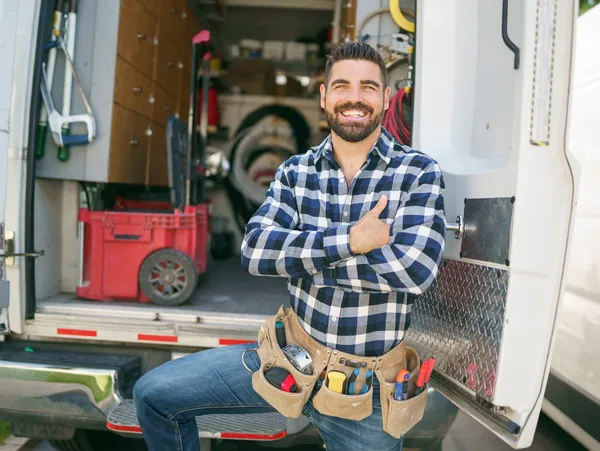 Smiling man by van with tools