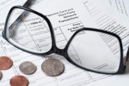 coins and glasses on 1099-K tax forms