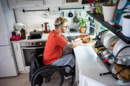 a wheelchair user washing dishes at home
