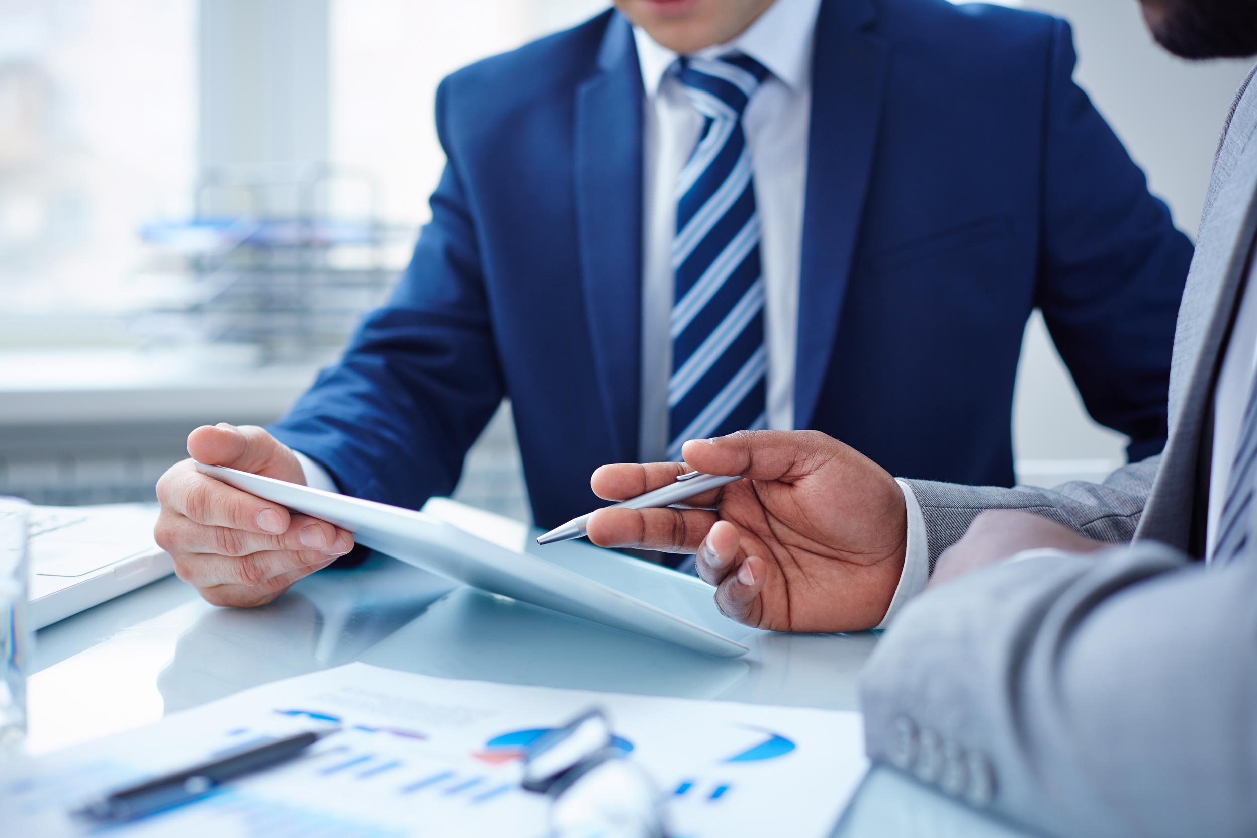 Two professionals discussing financial numbers on a laptop