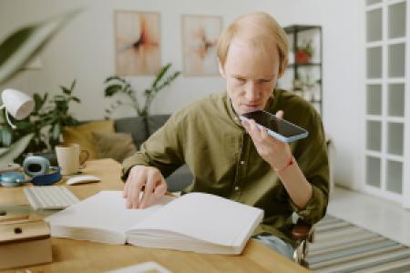 a blind person reading Braille and recording voice