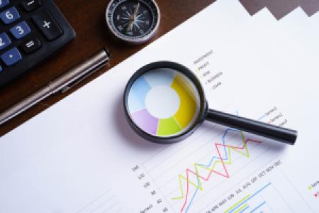 magnifying glass on data analysis charts
