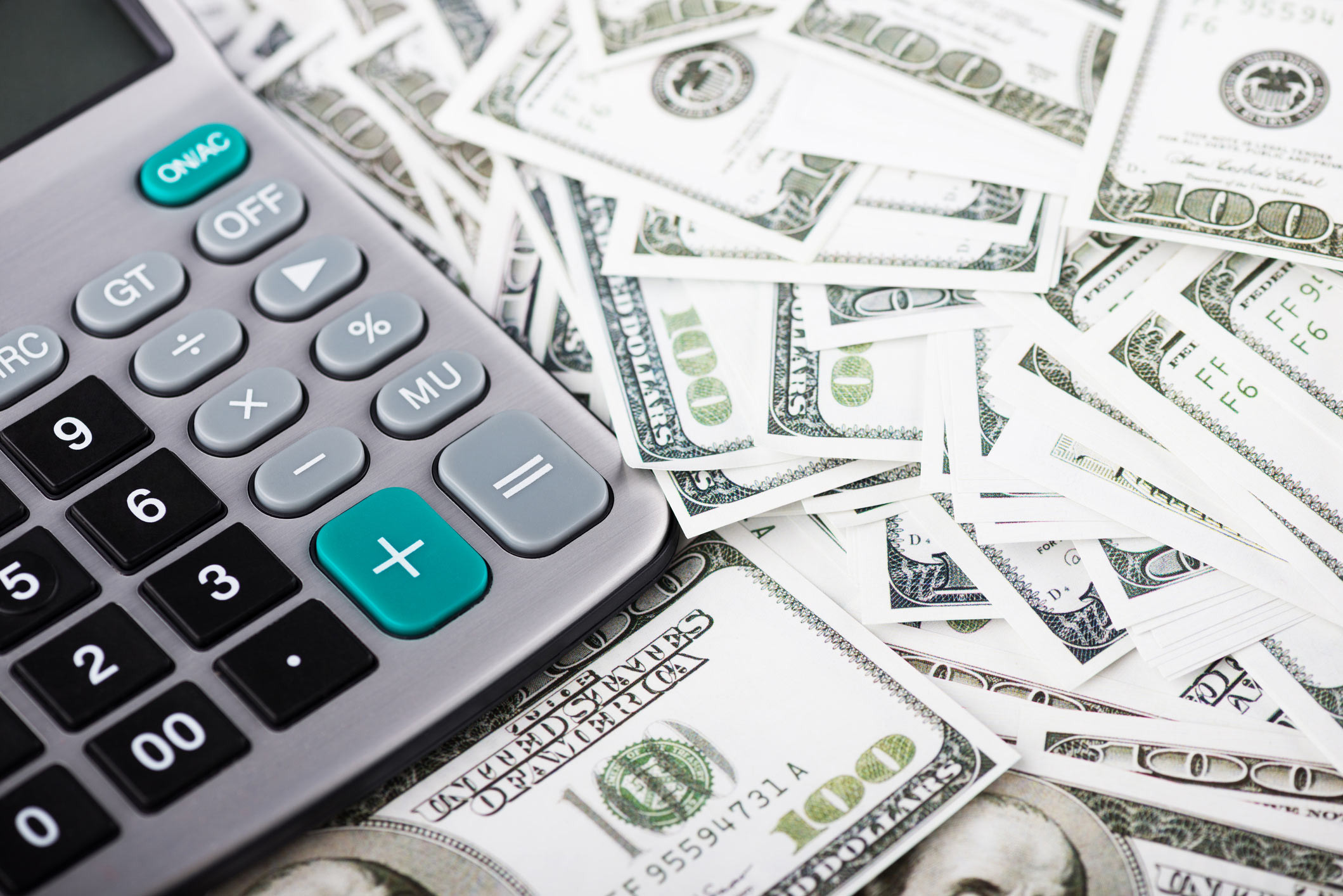 calculator on top of a pile of cash