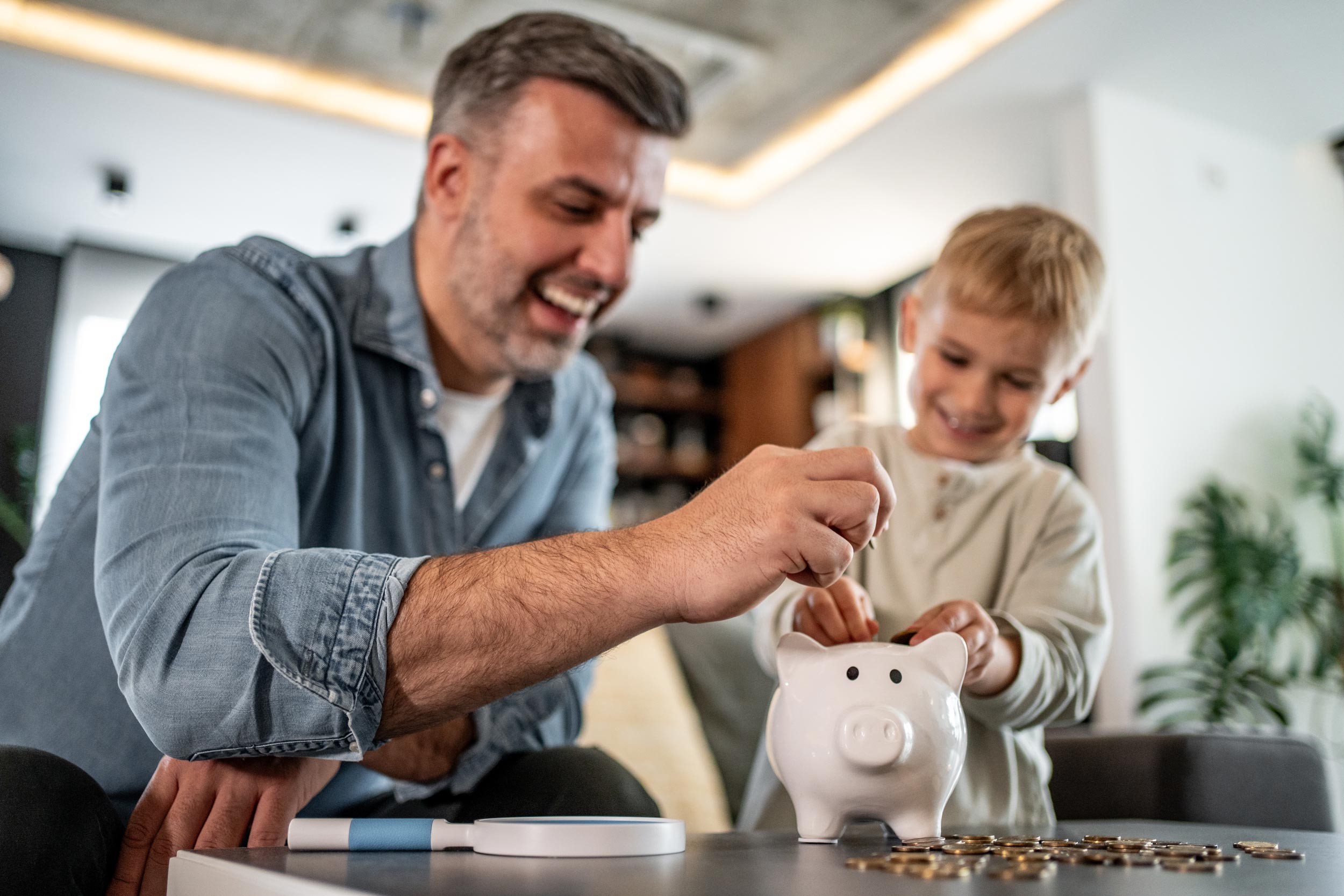 Father and son saving money with a piggy bank