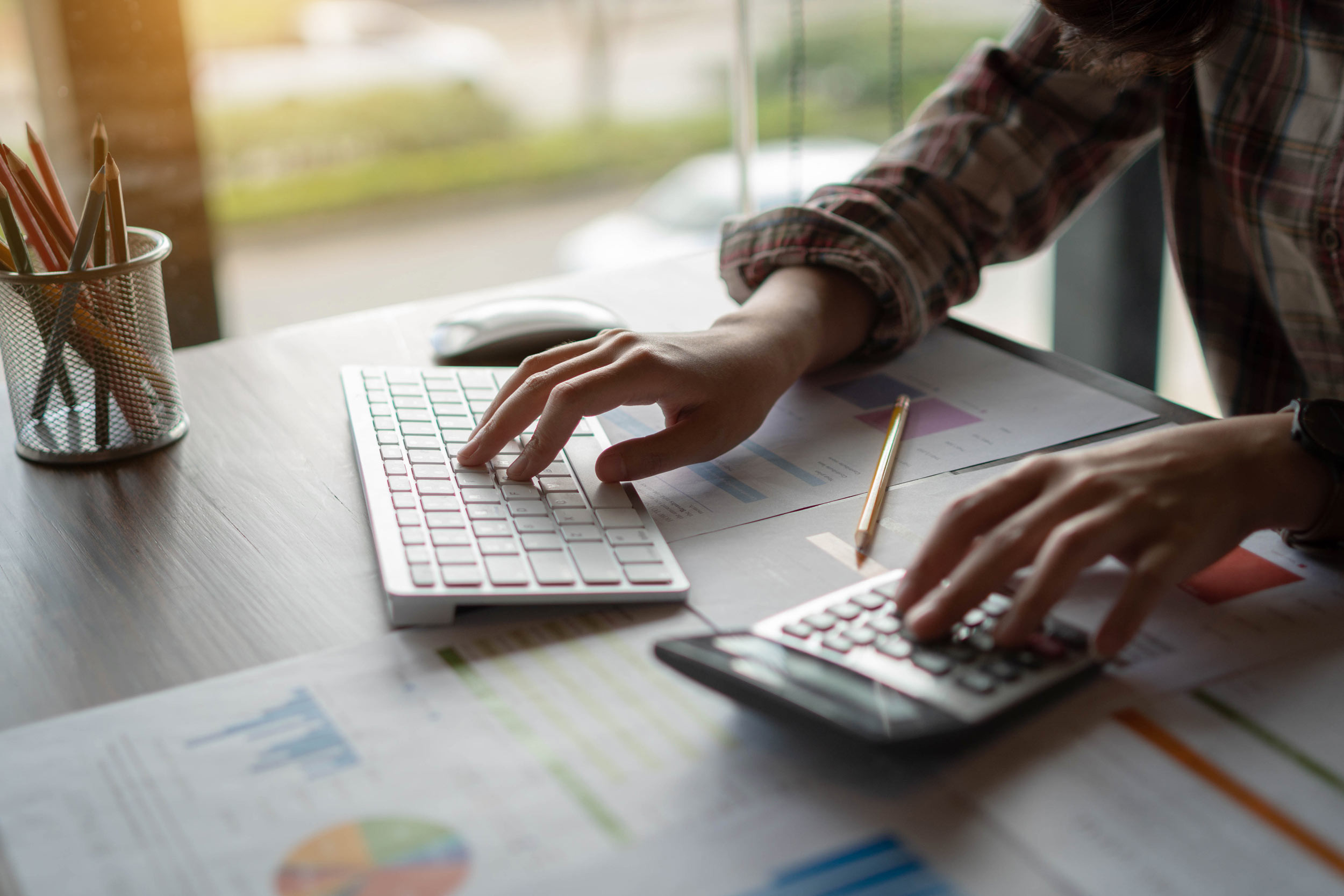 An accountant calculates data to input on his computer