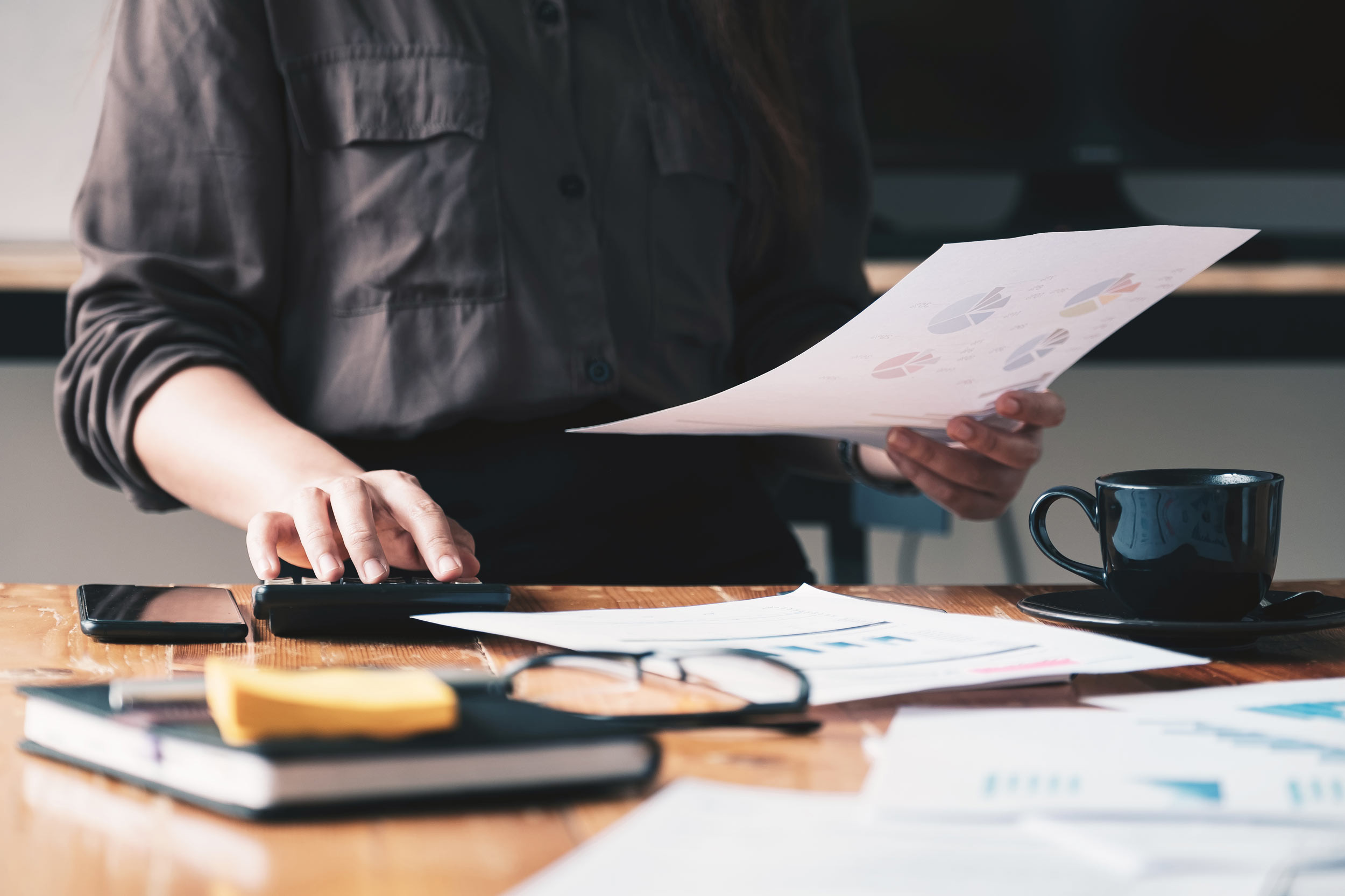 An accountant reviews printed out data at his desk