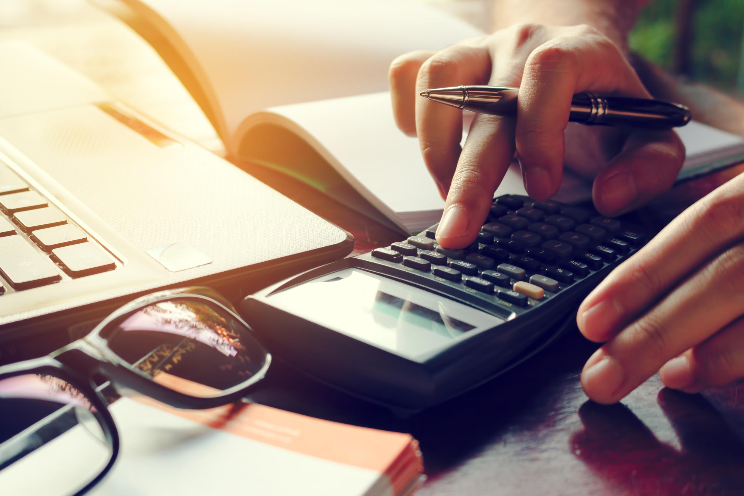 Accountant's hands typing a calculation into a calculator