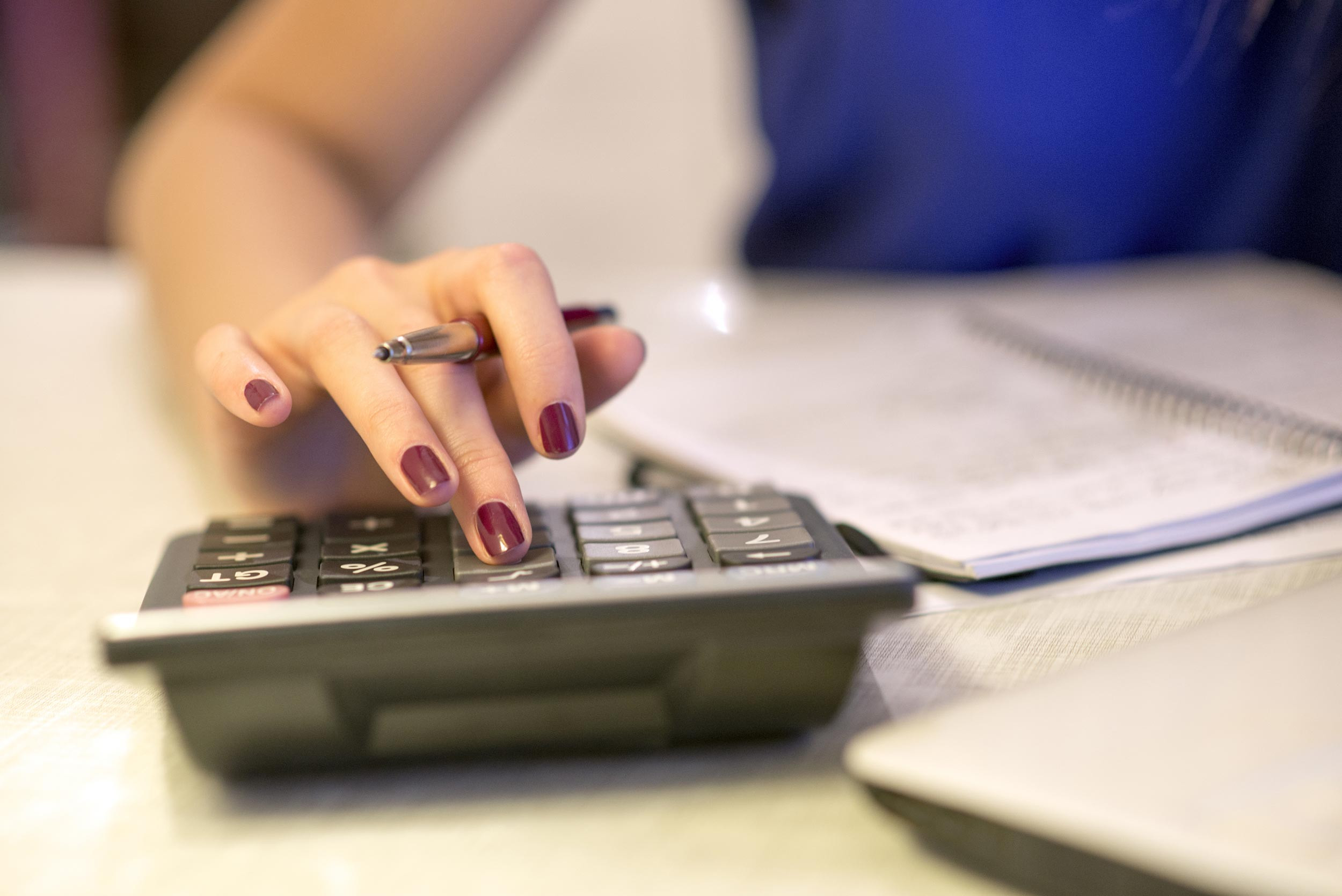 A female accountant types into a calculator