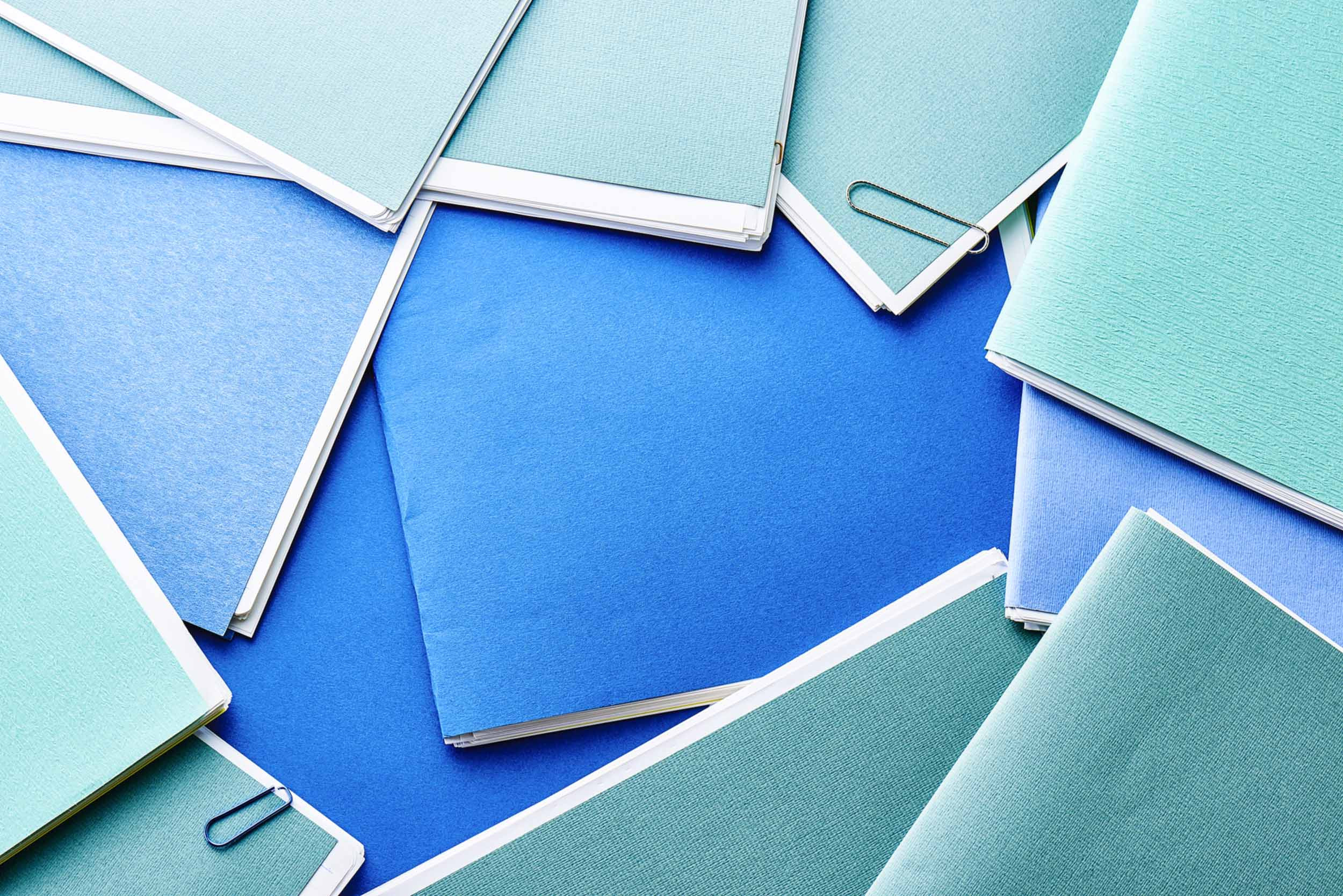 A bookkeeper's blue folders spread out on a desk