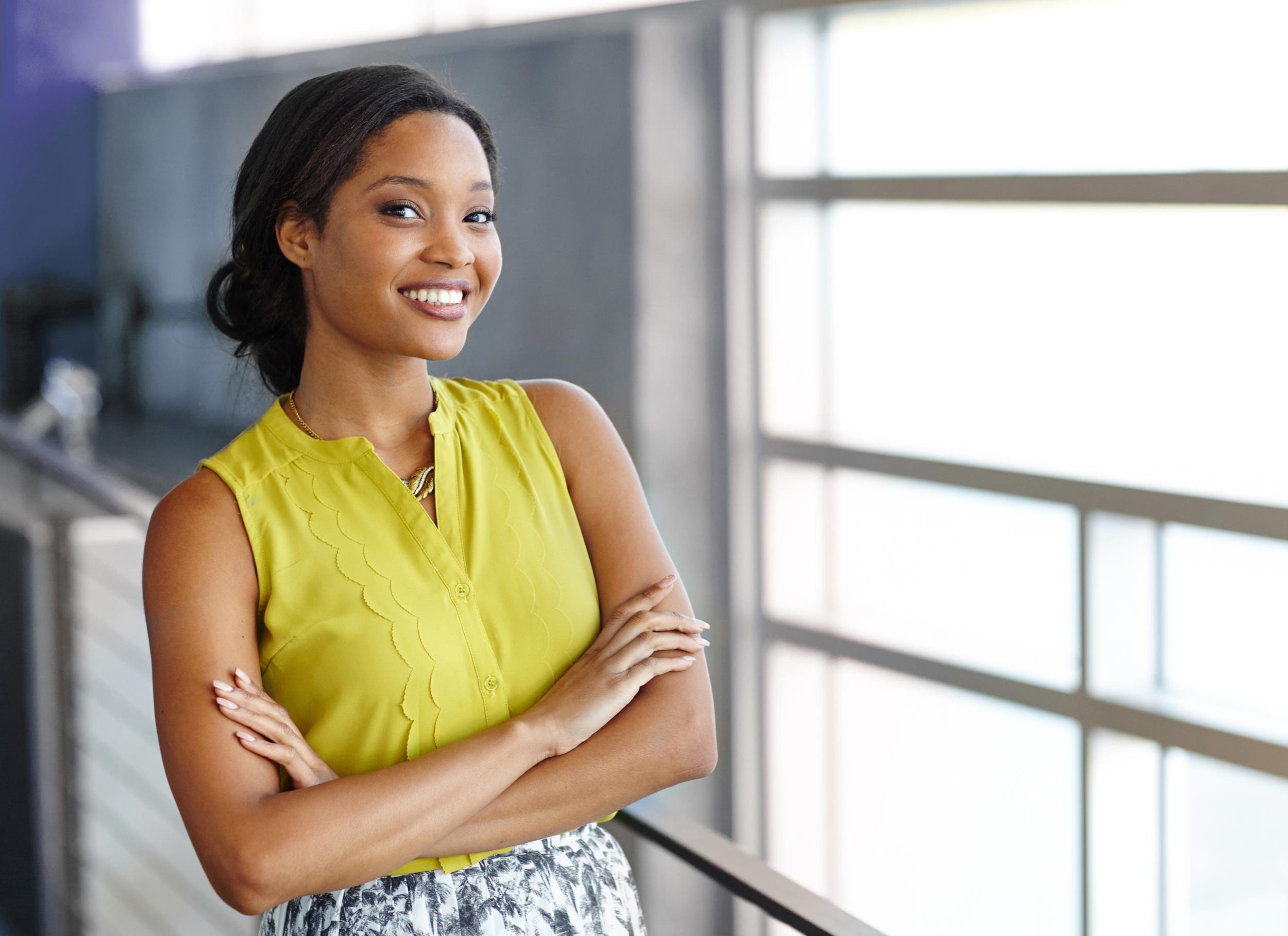 Headshot of an African American business woman crossing her arms and smiling