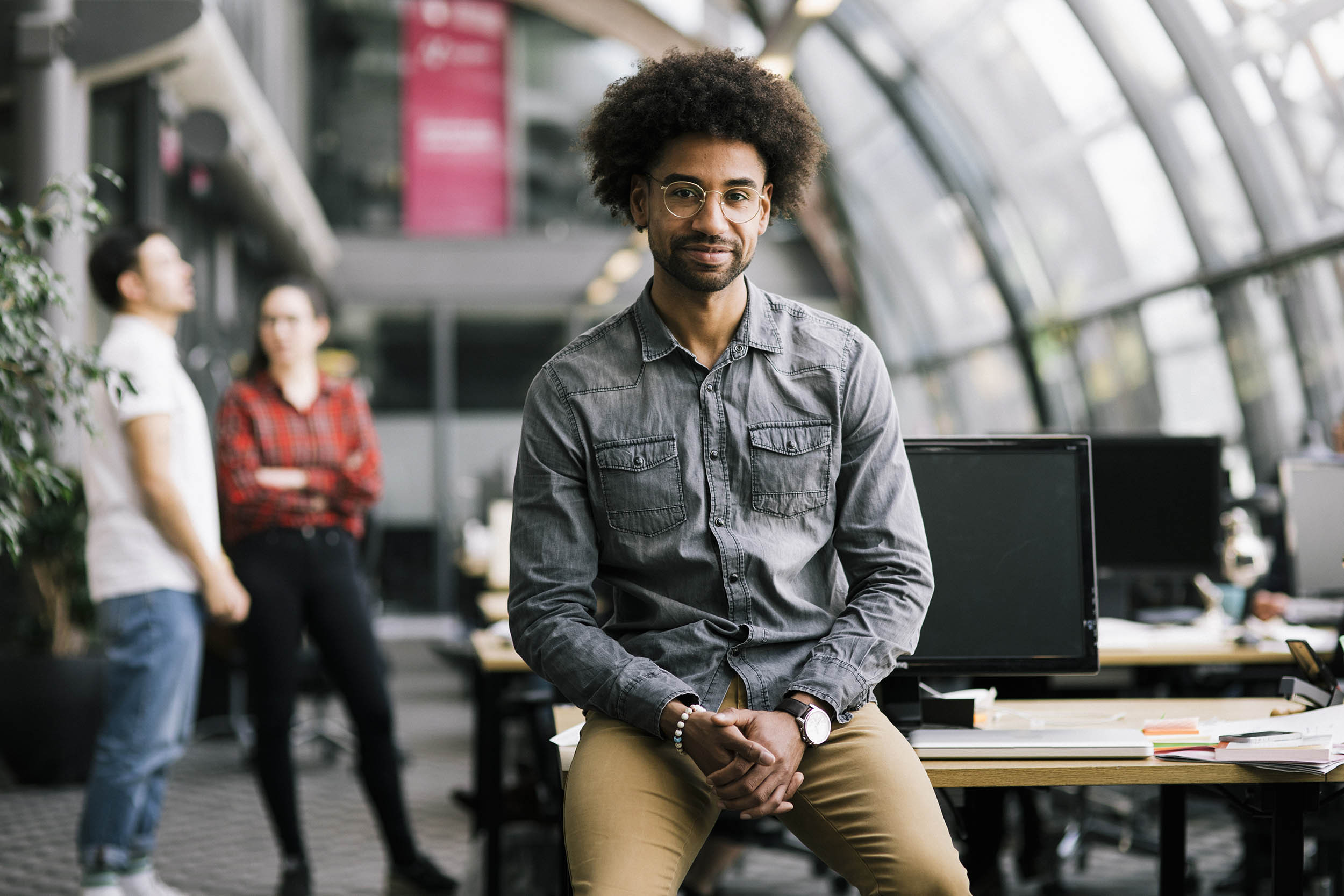 An African American entrepreneur sits on his office desk