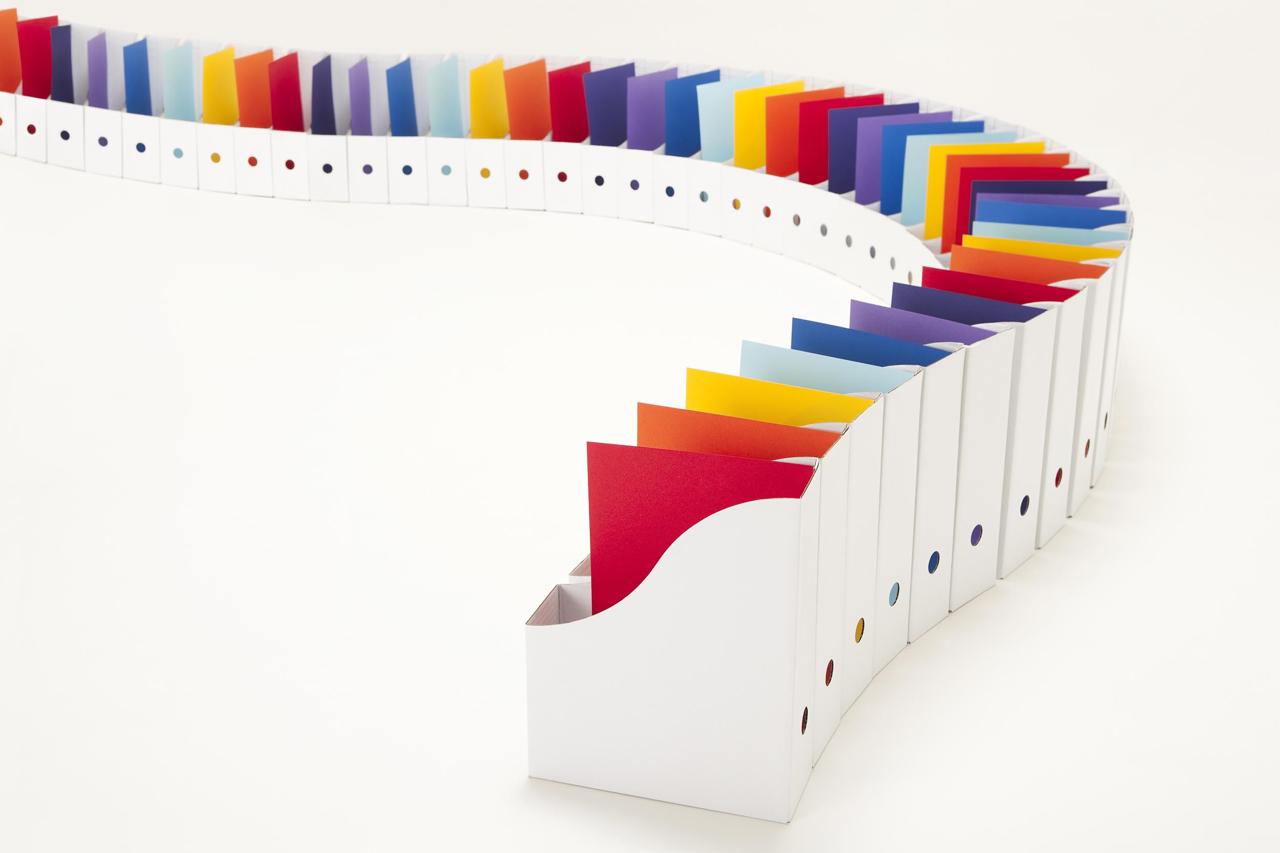 Paper production line, box files containing colourful A4 paper sheets snake off into the background