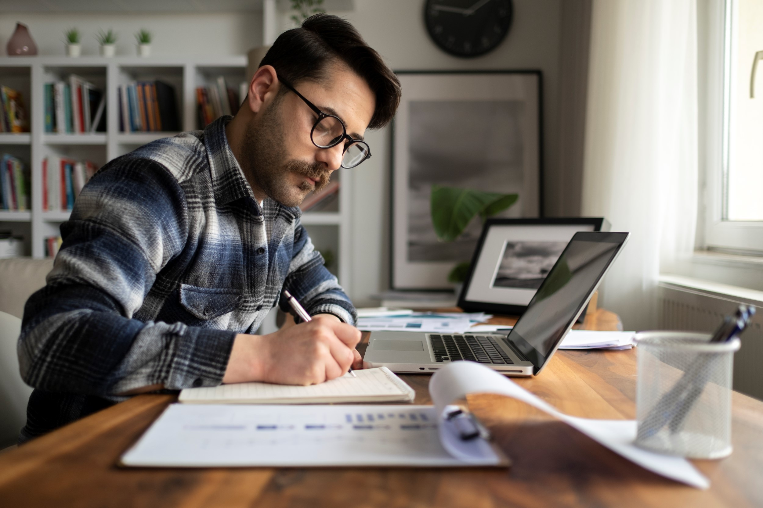 accountant going over documents while working on laptop