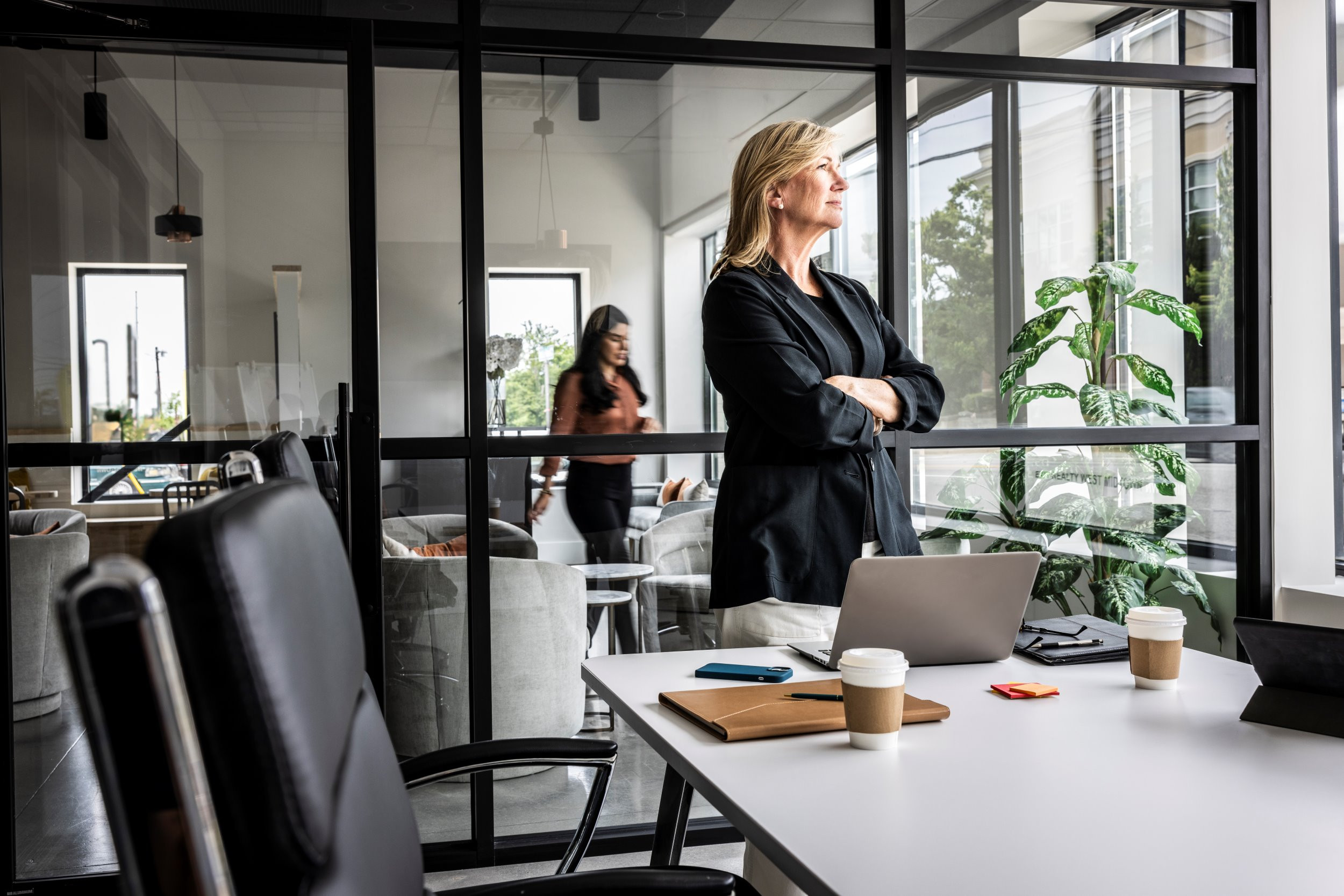 business woman looking out the window in a conference room