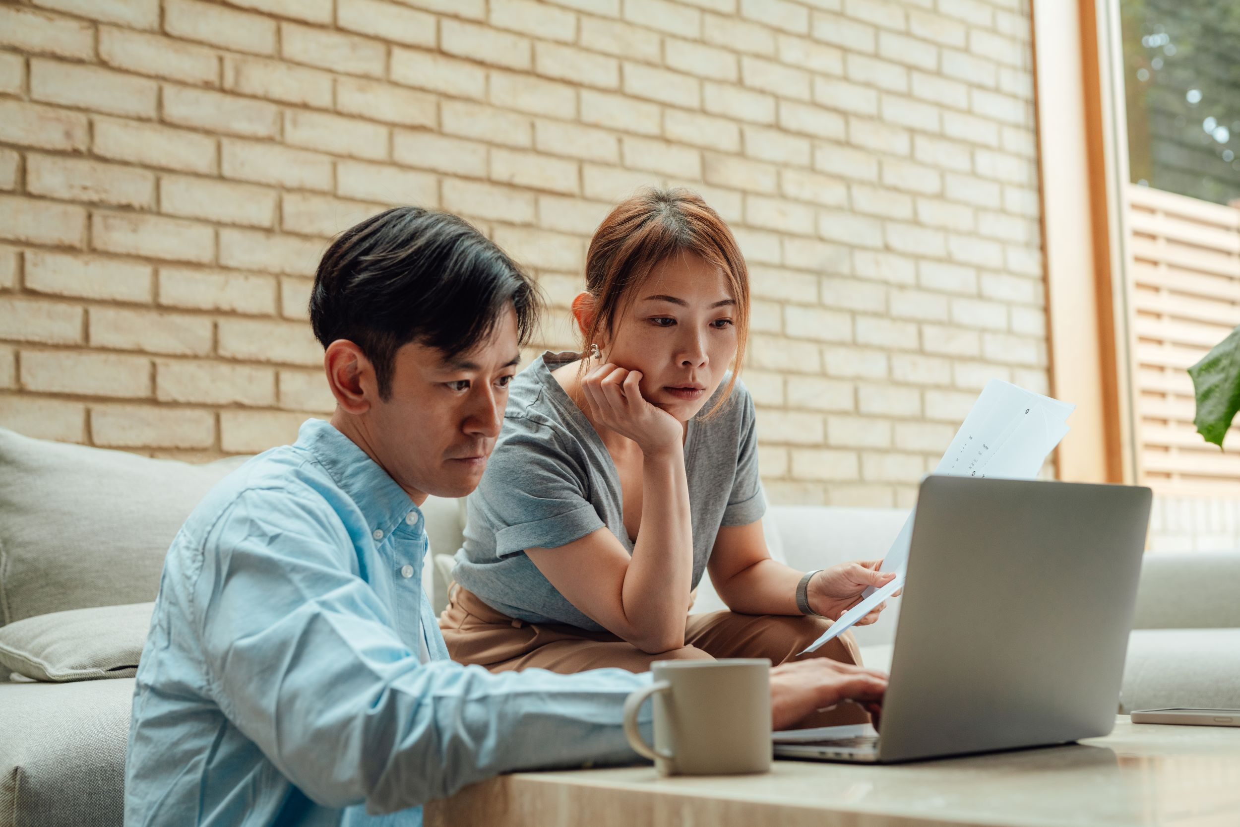 a couple figuring out financial documents at home