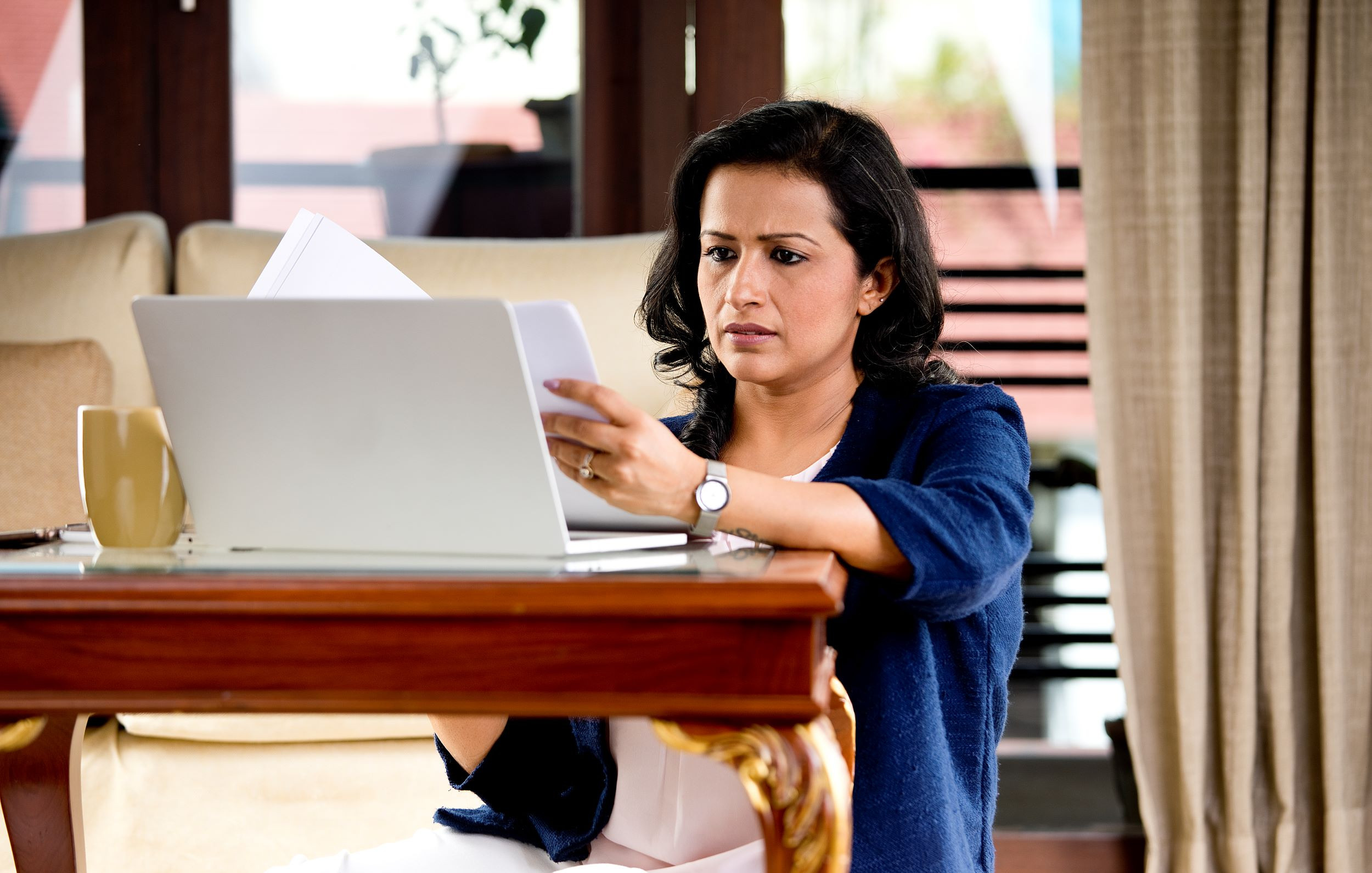 a frustrated person reading documents at home