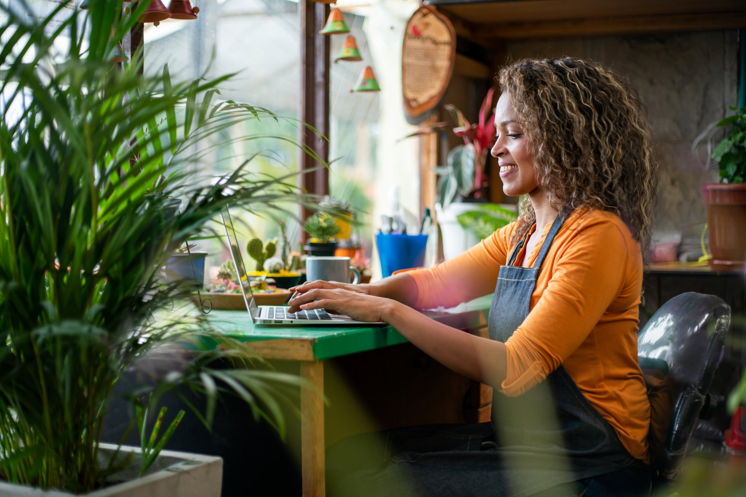 happy flower shop owner working on the laptop