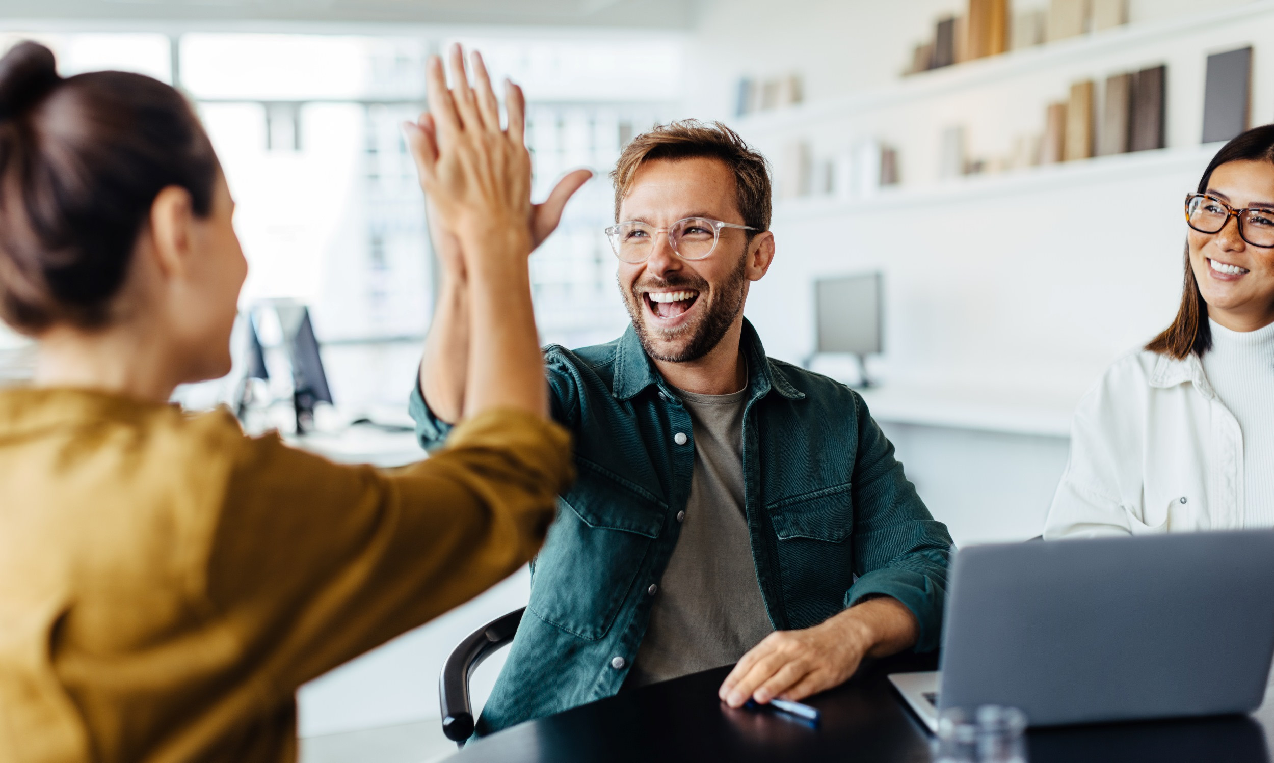 a high-five between two coworkers in celebration