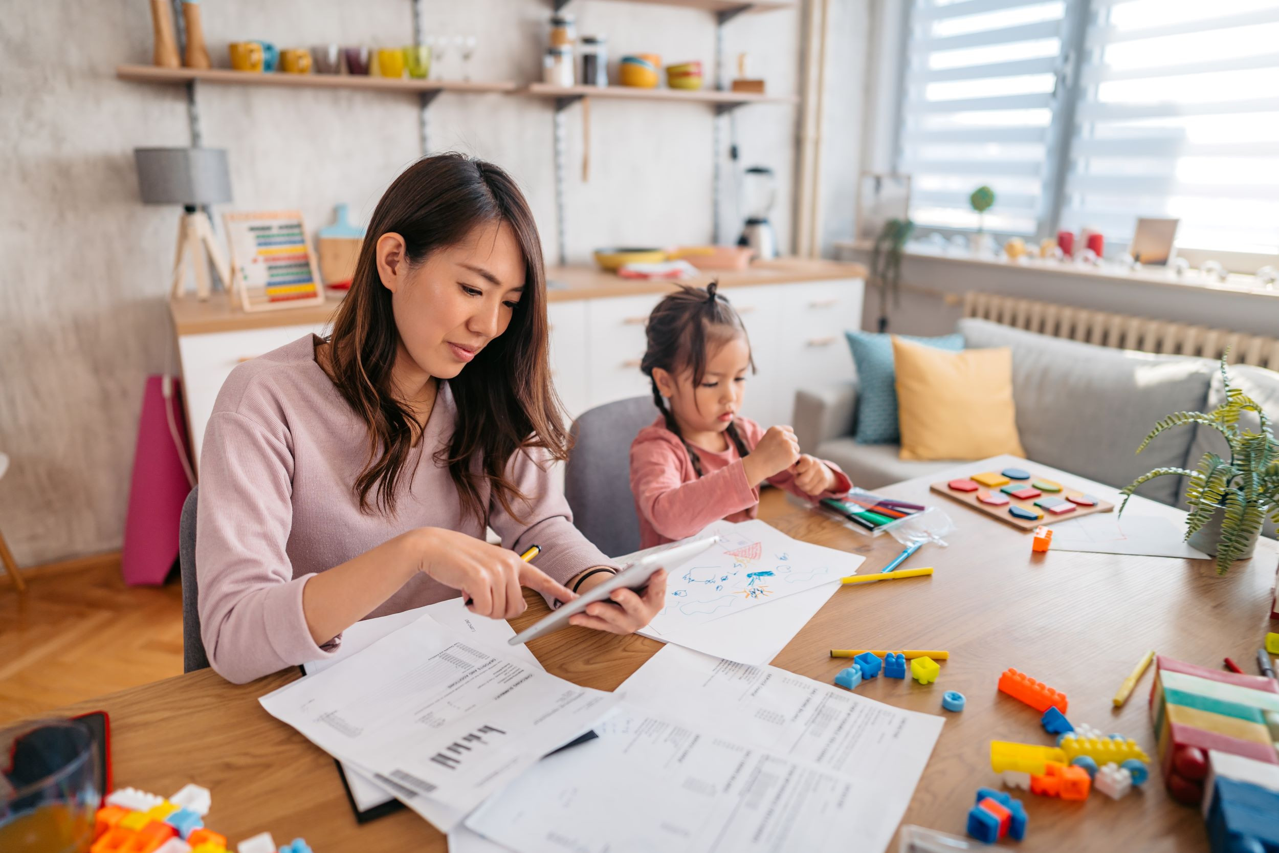 a mother looking at finances at home with her child