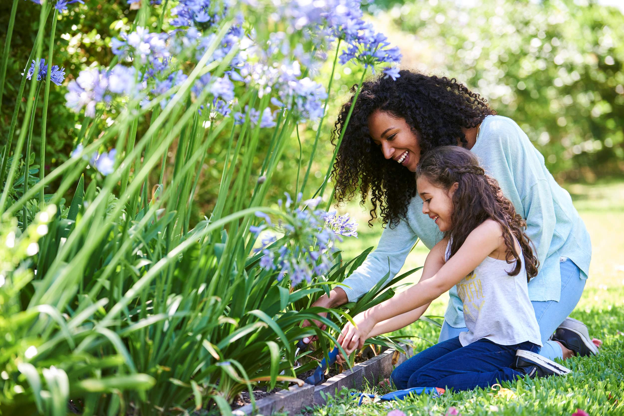a mother and child planting flowers in the spring