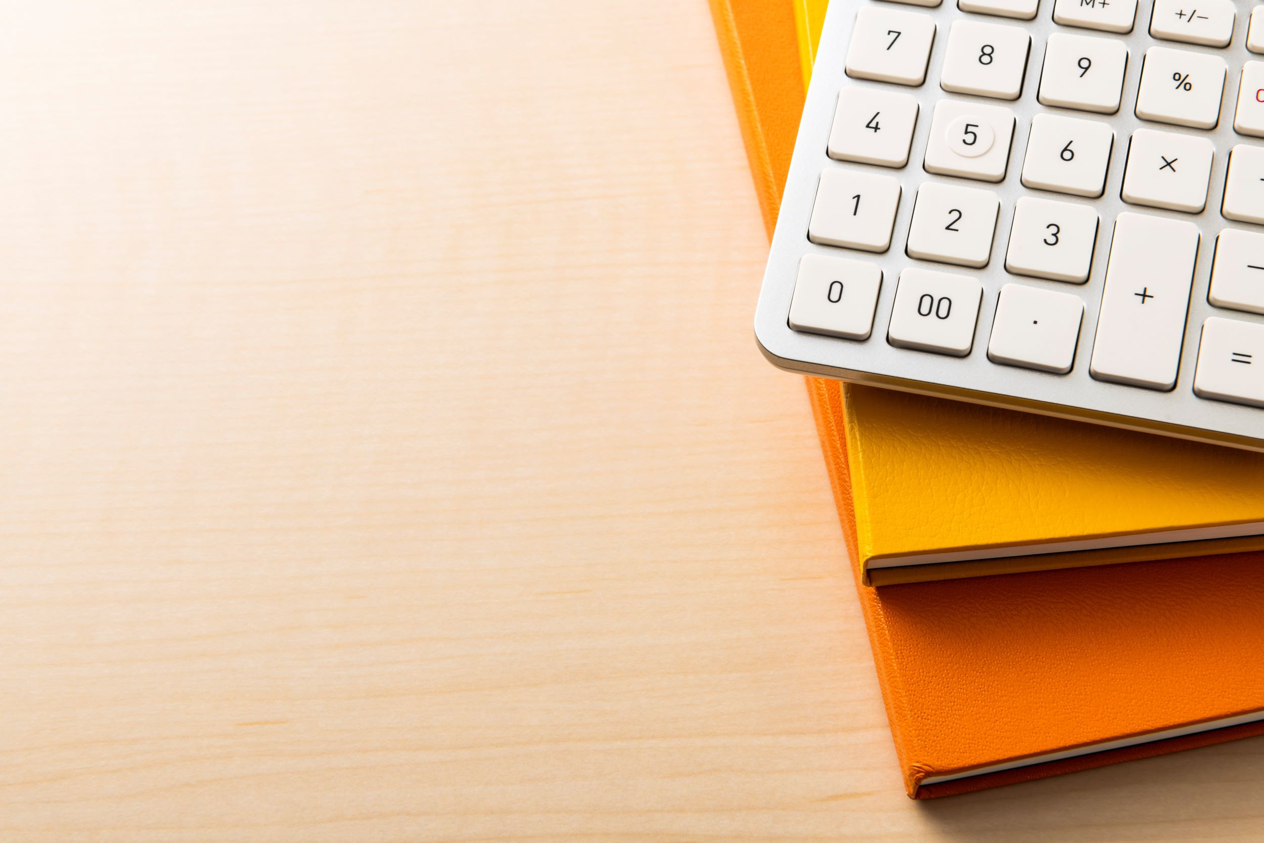 a desk with a calculator and two notebooks