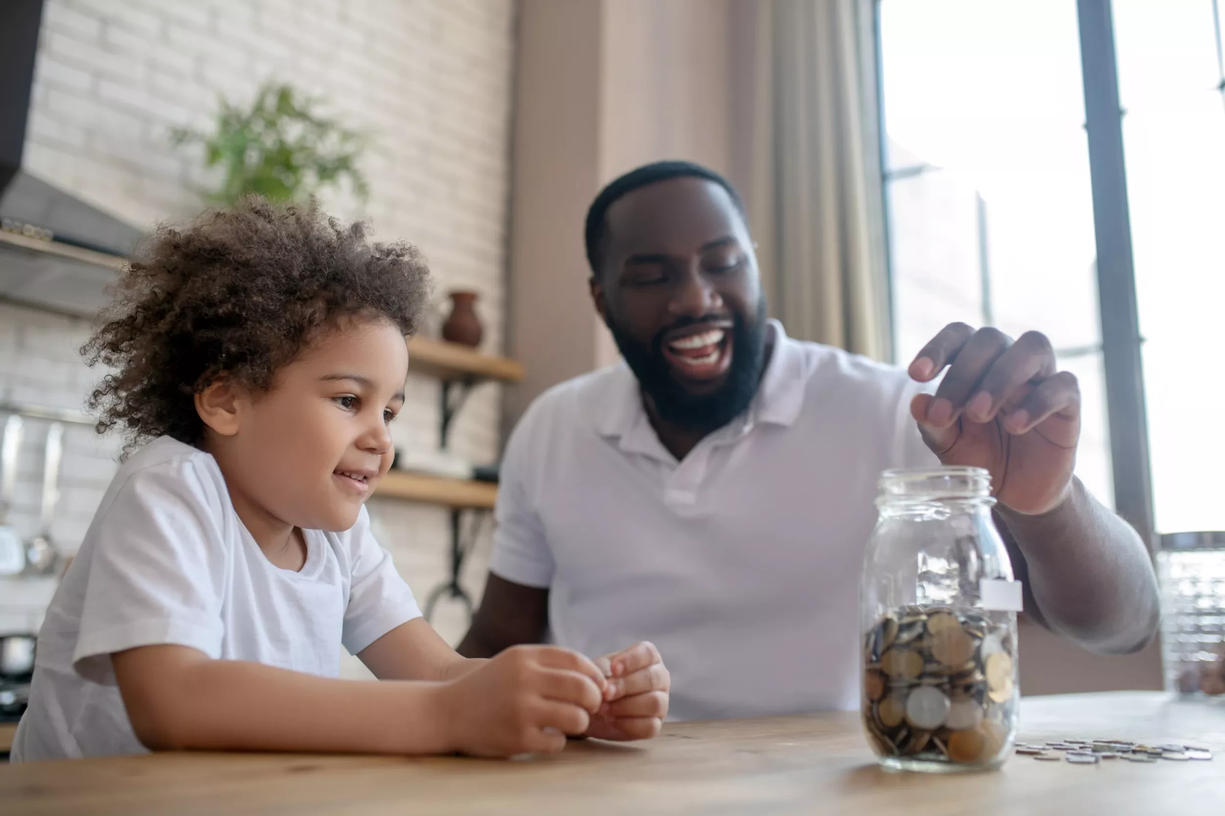 a father and child saving money in a coin jar
