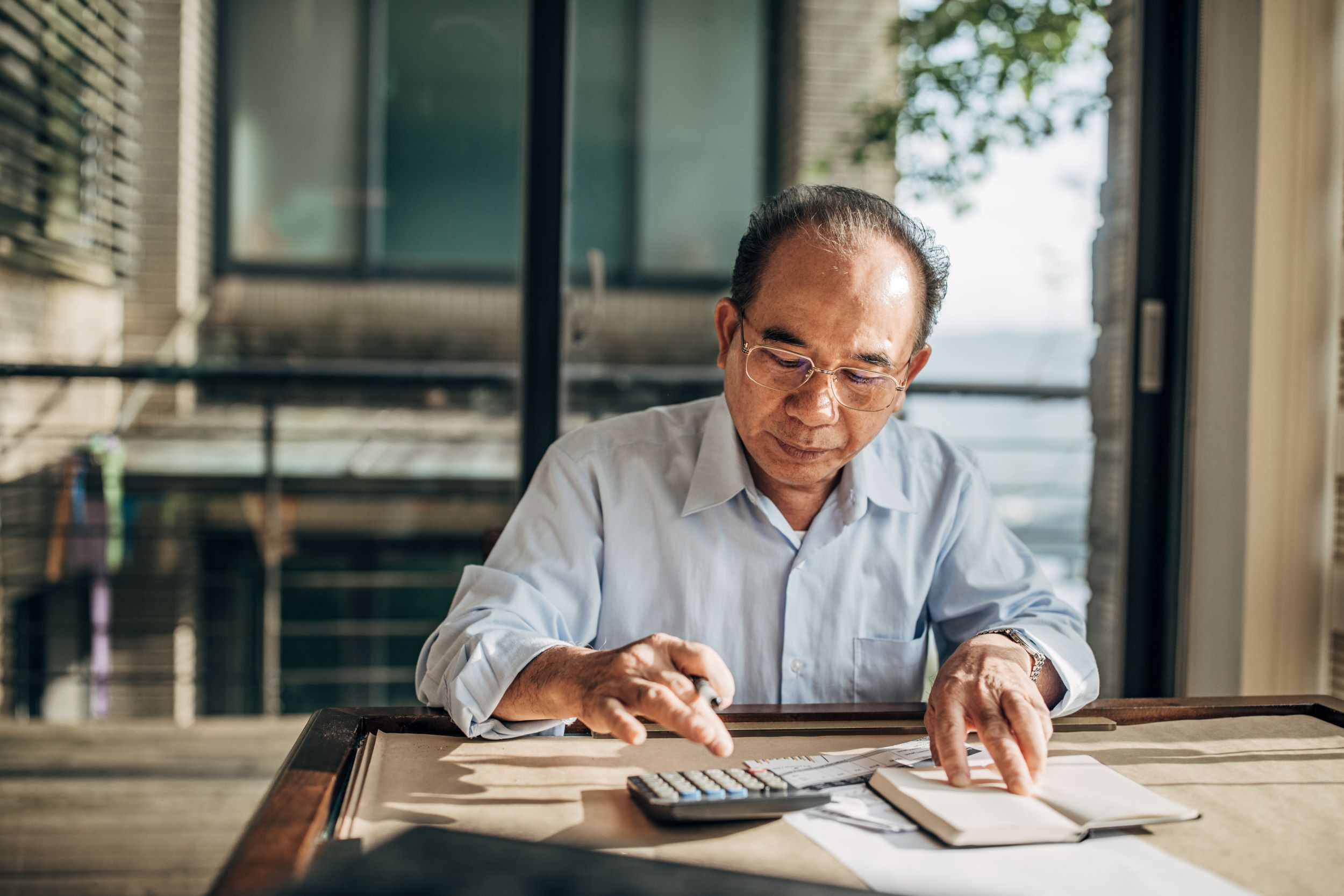 a senior person calculating finances at home