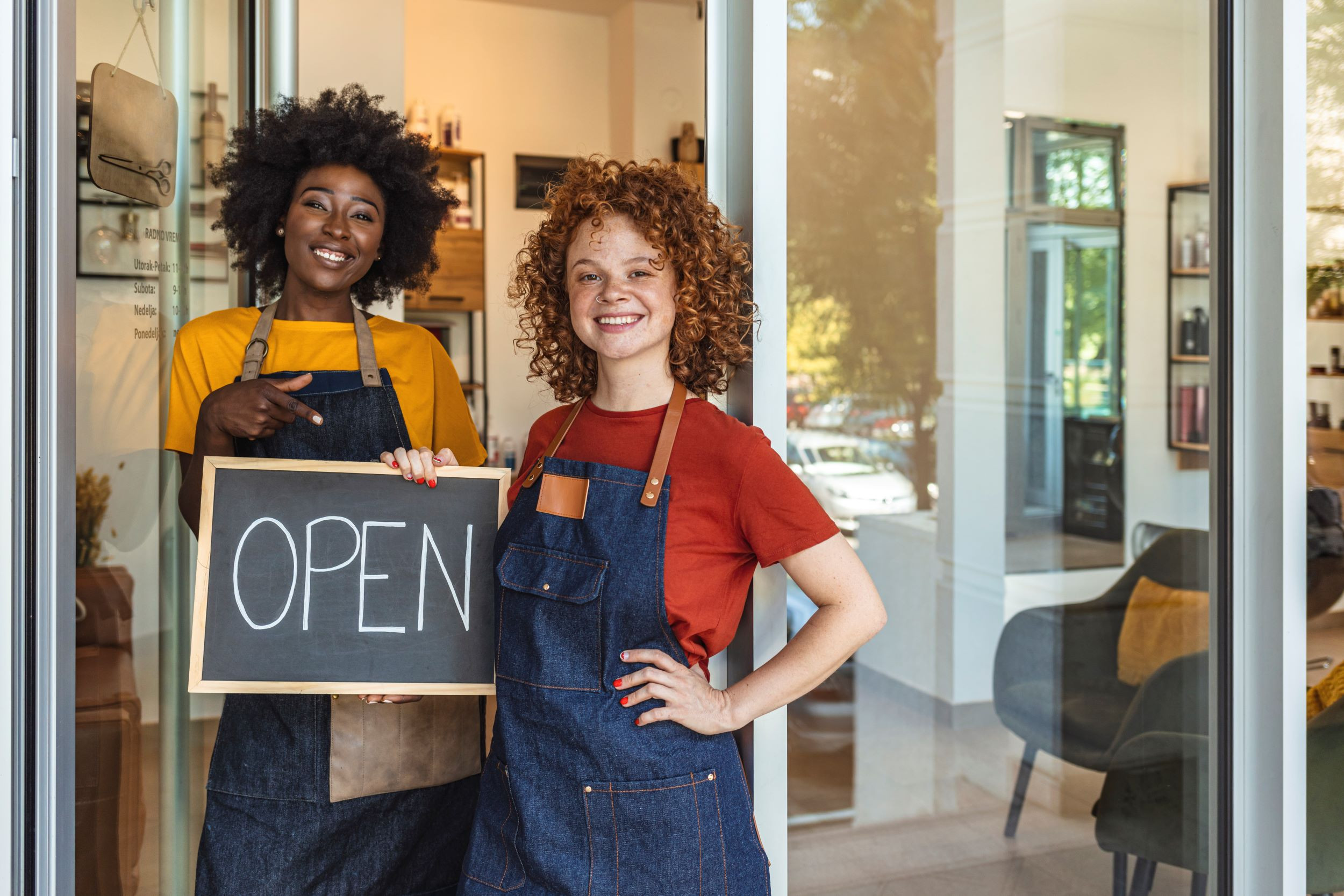 two business co-owners standing in front of their store