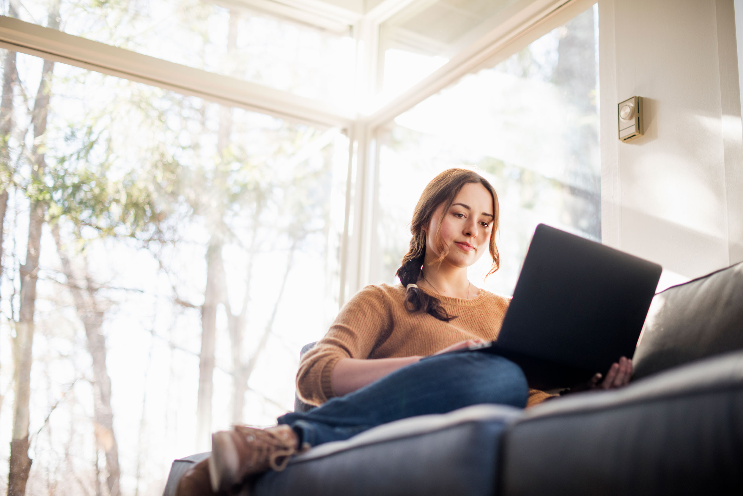 a person working on laptop on a sofa