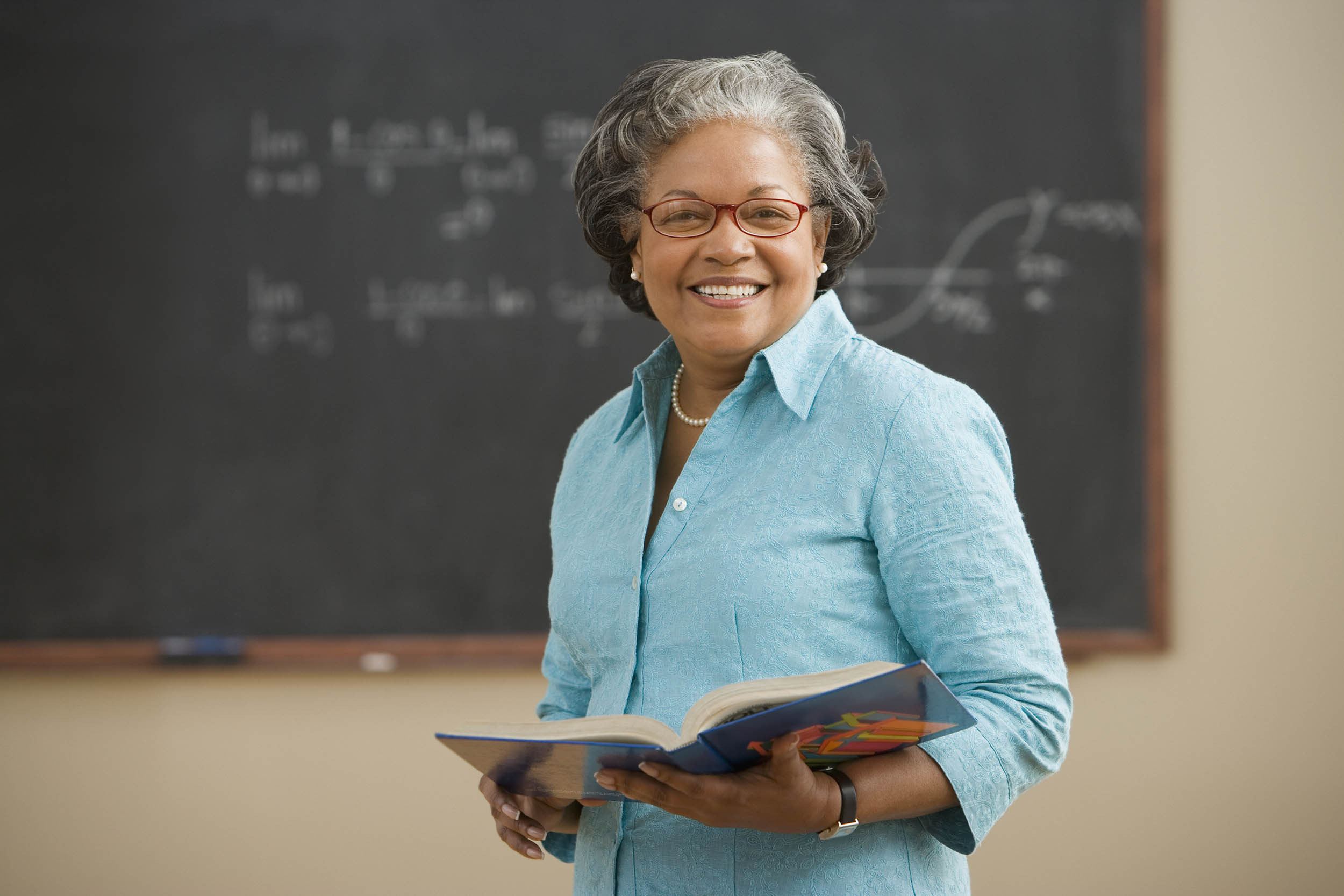 teacher teaching the lesson using the black board
