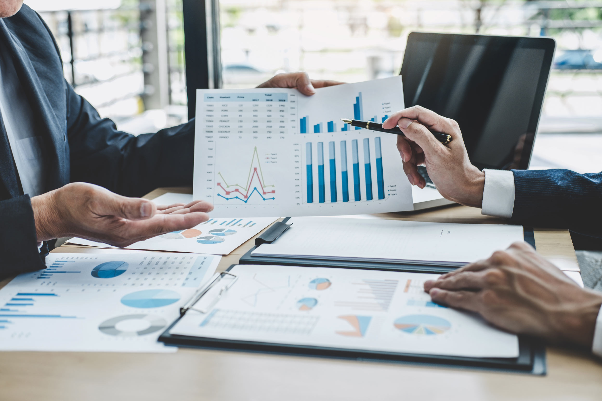 two person are in meeting with the graphical reports