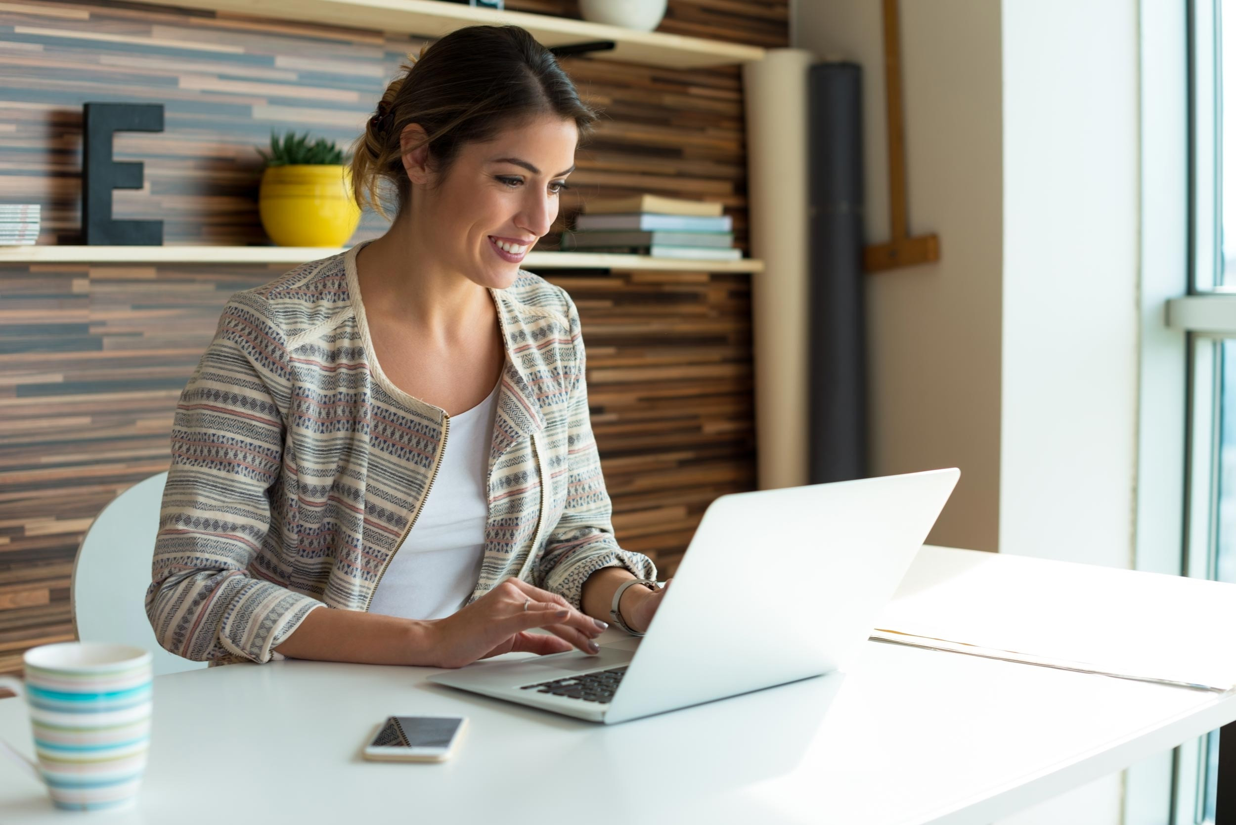 Happy businesswoman working on computer