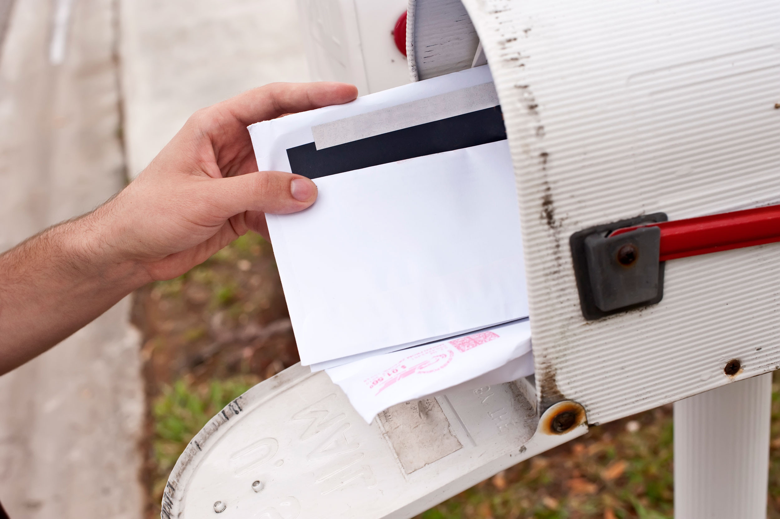 a person taking letters from the mail box