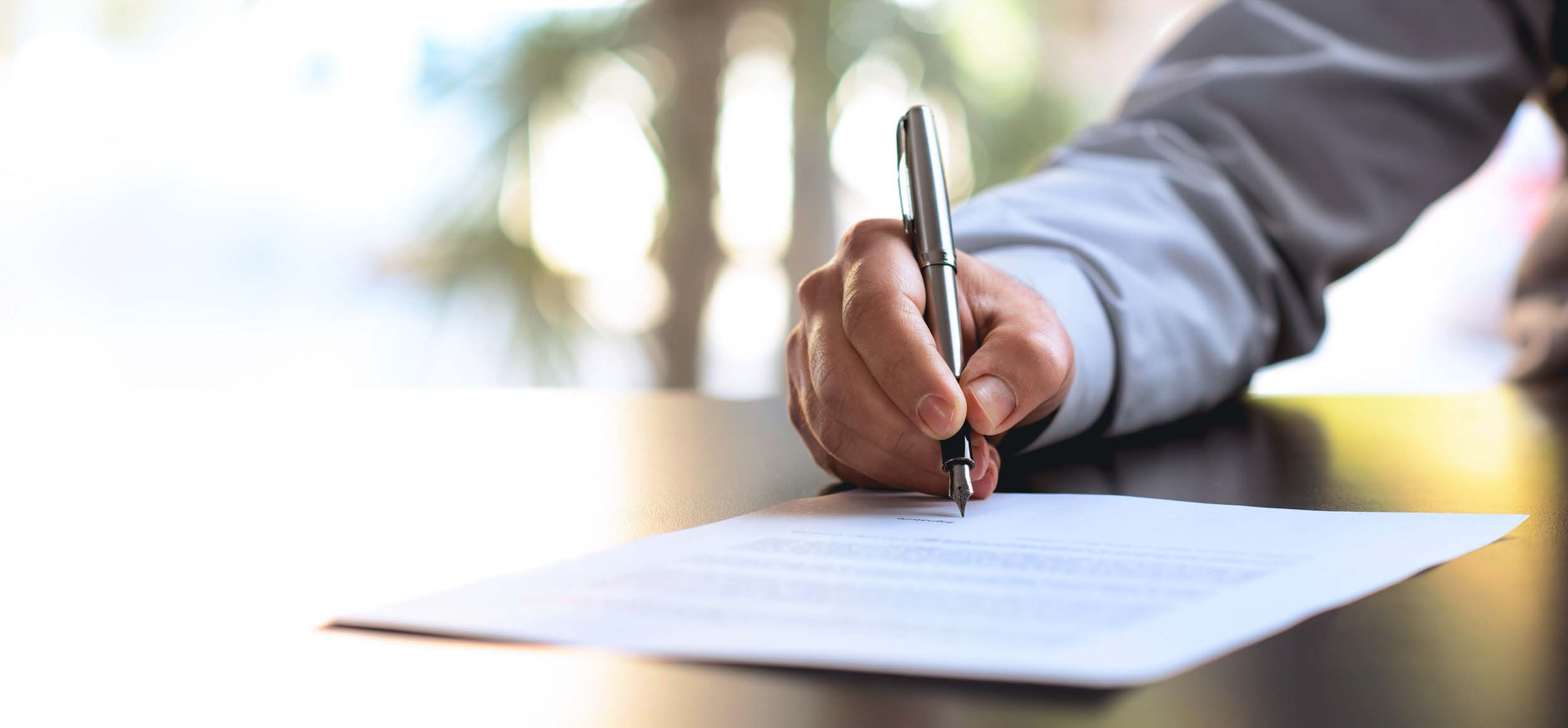 a person signing contract paper
