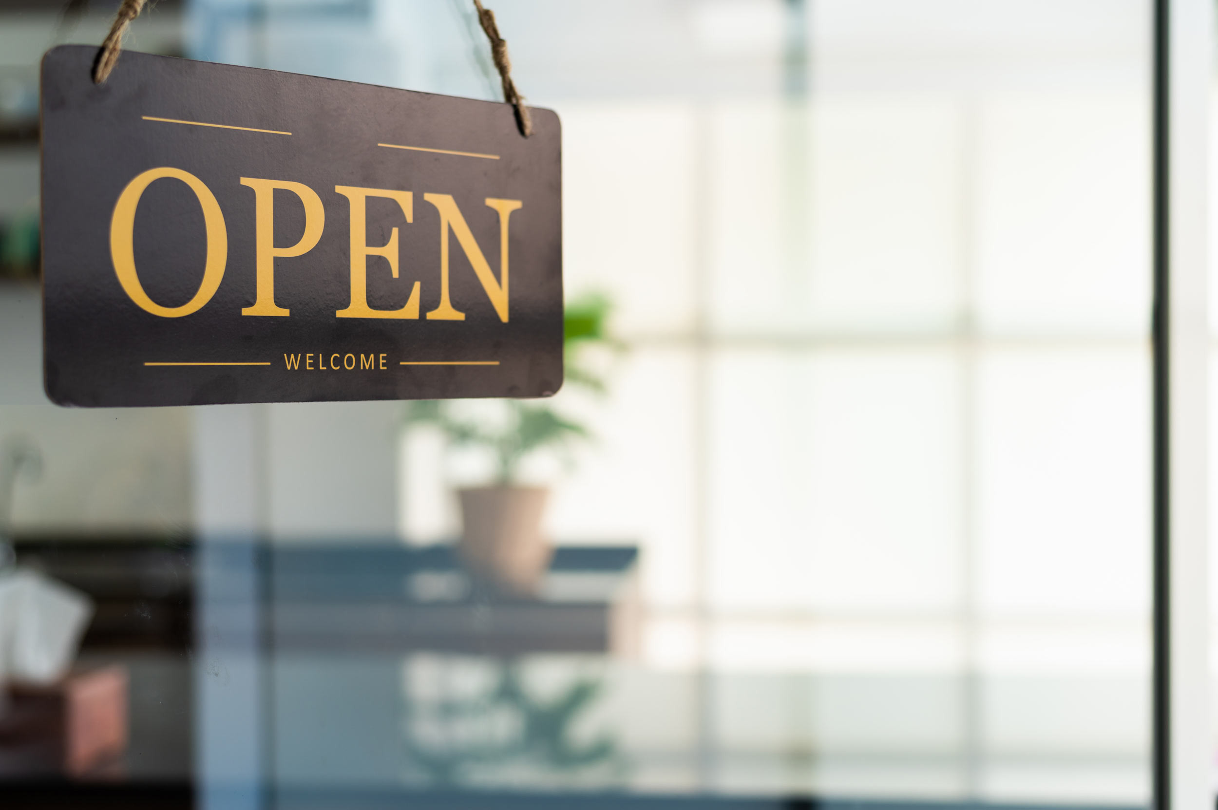 an open sign board is hanging on shop door
