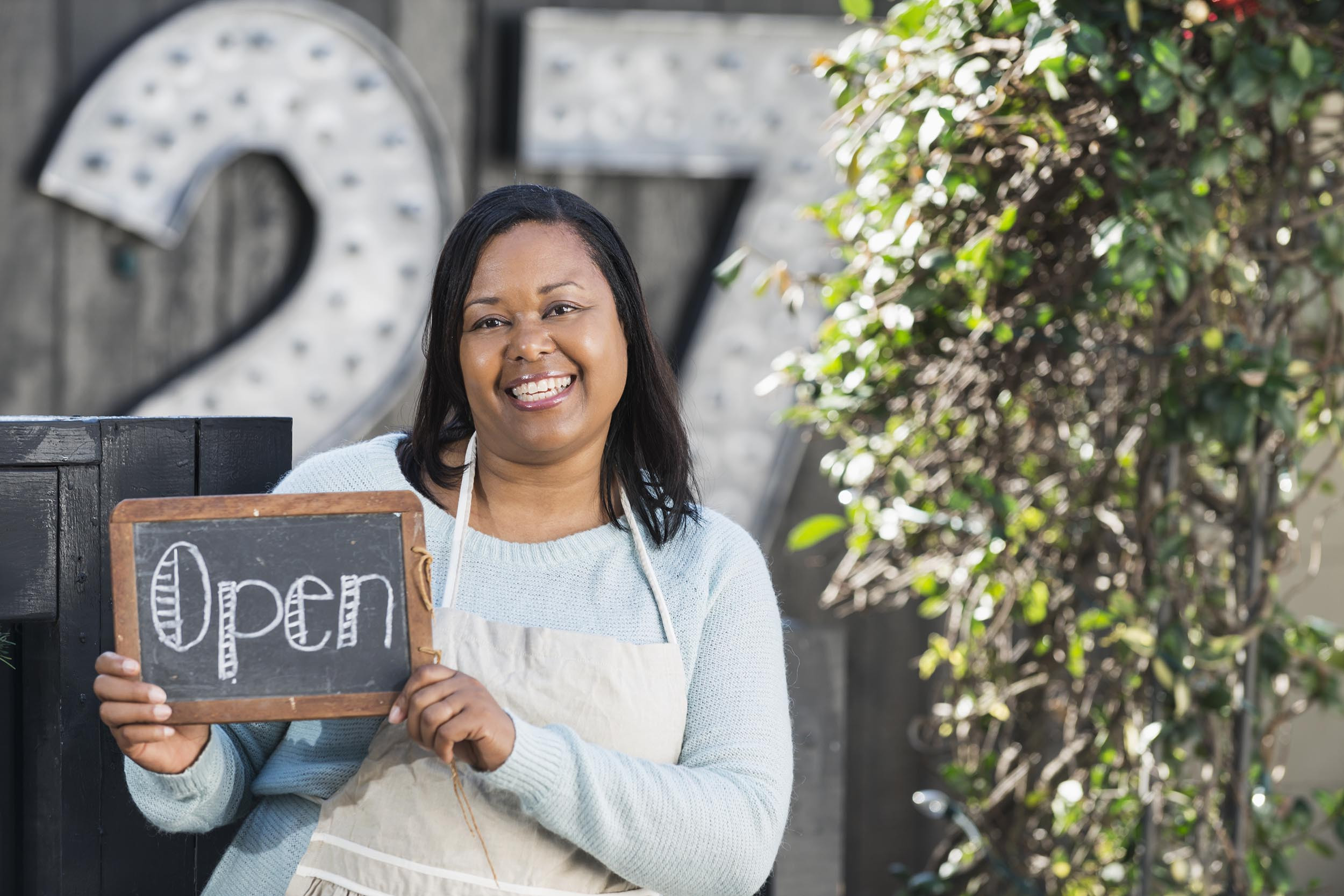 business owner with the open sign board
