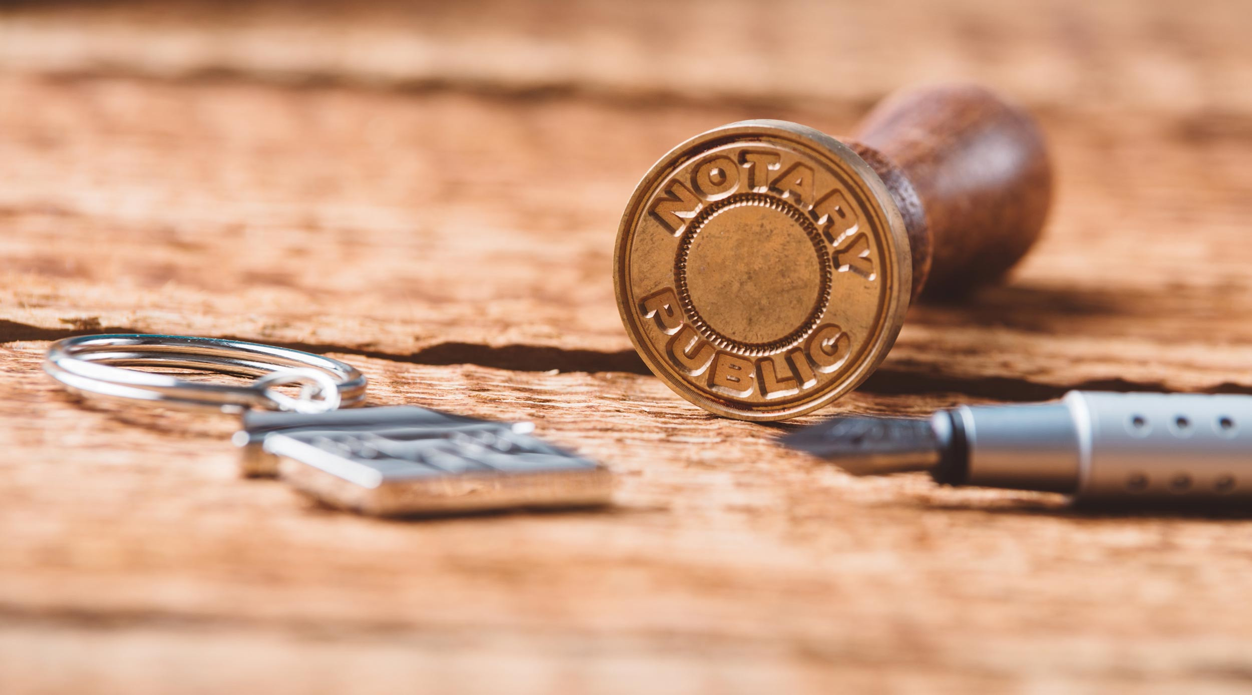wooden desk with pen, key and notary stamp