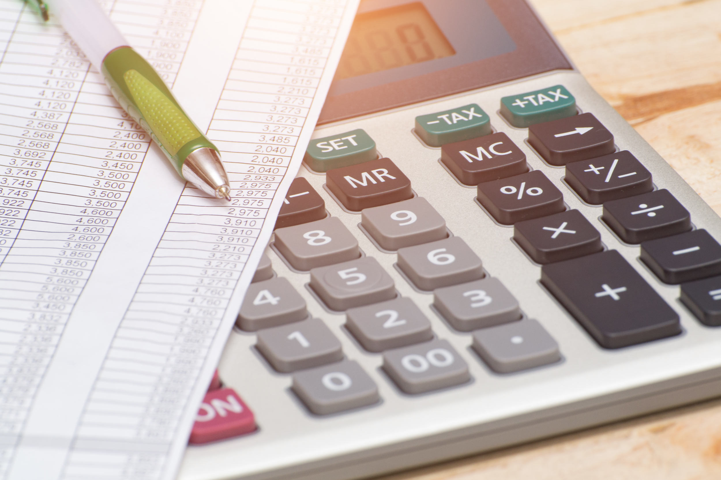 calculating auditing paper with the calculator and pen
