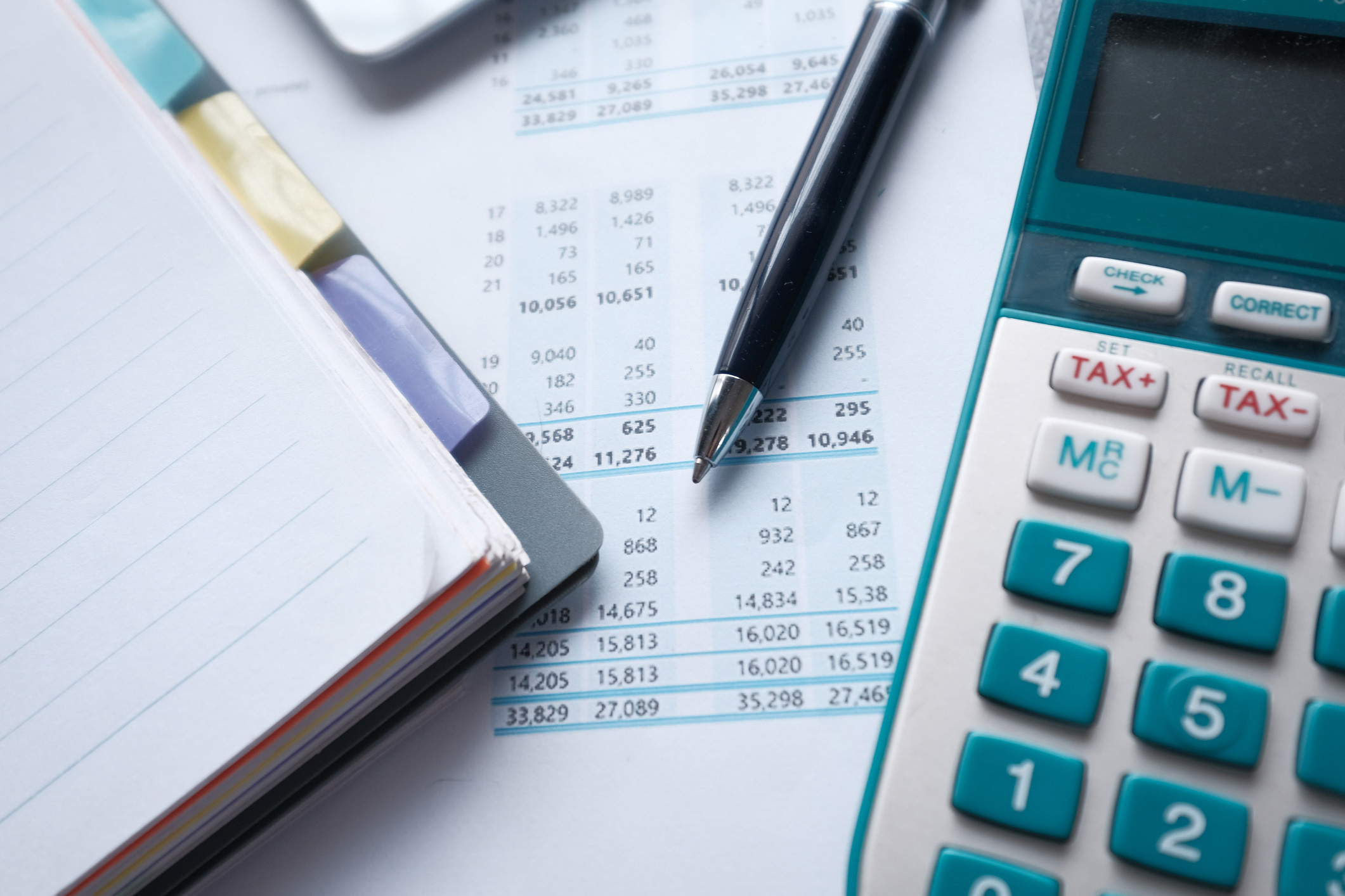 payroll tax auditing with notepad, calculator and pen