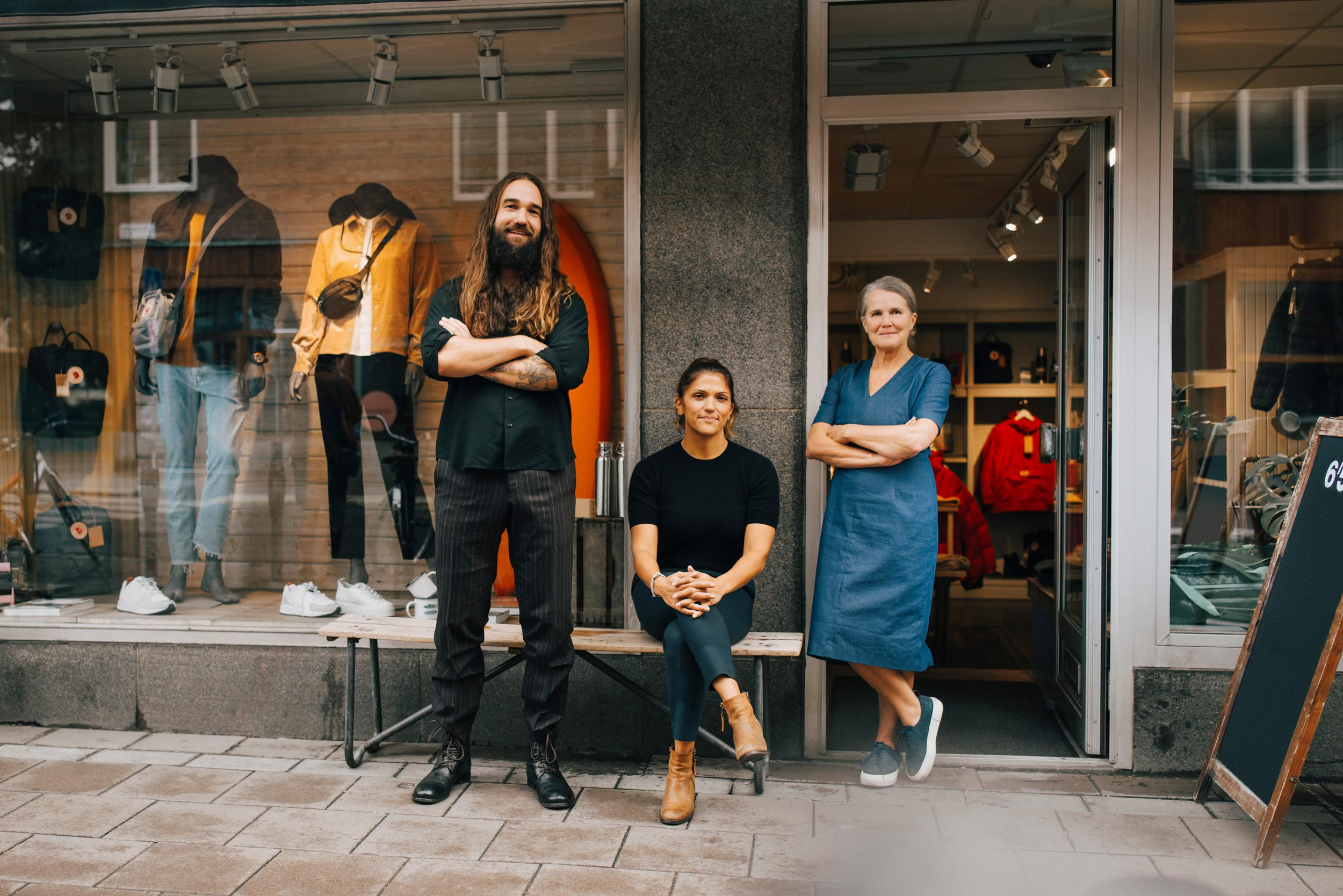 a small business owner and staff standing in front of the shop