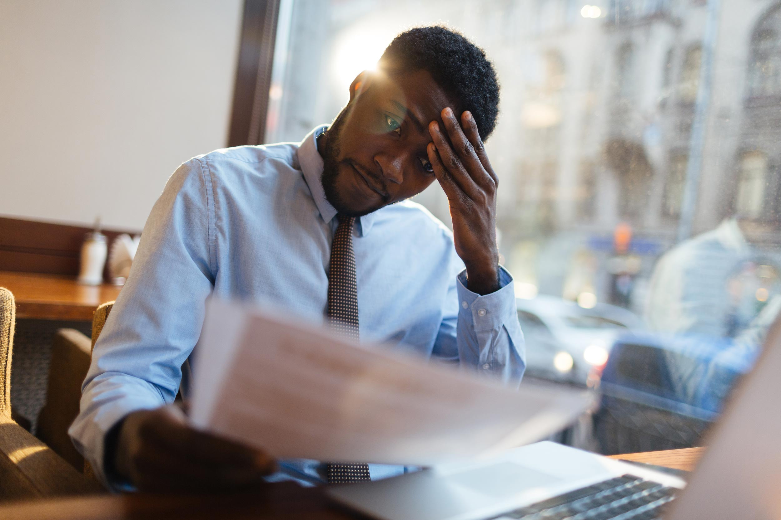 stressed person at computer and holding document