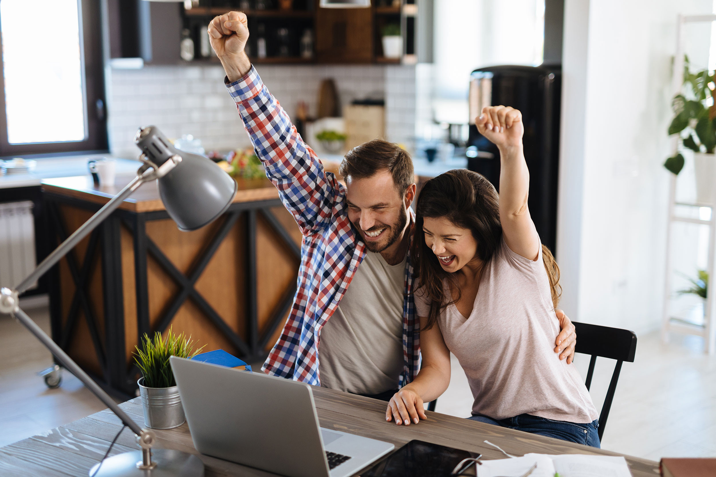 happy couple using laptop at home