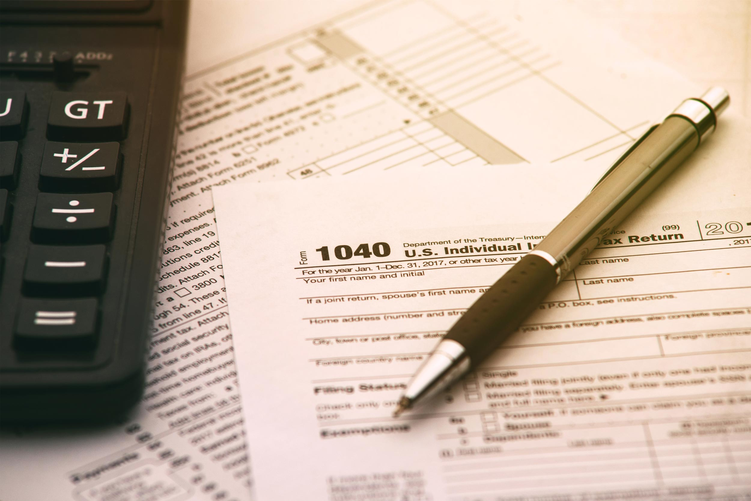 calculator and pen with tax form 1040