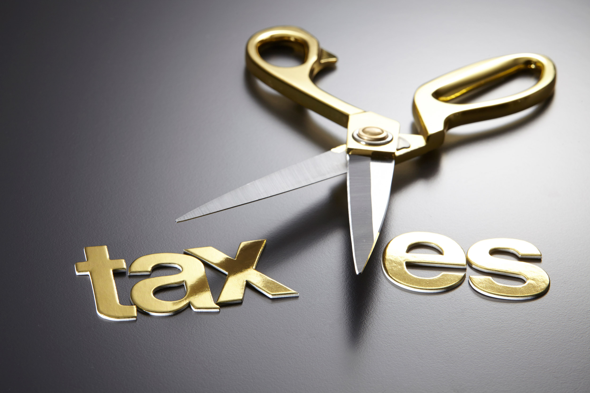 scissors cut the taxes on black background