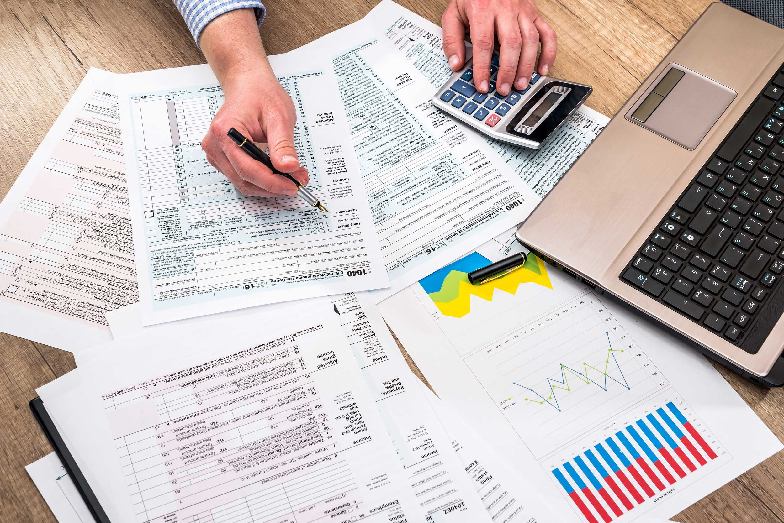 work with 1040 tax form and calculator with laptop at office