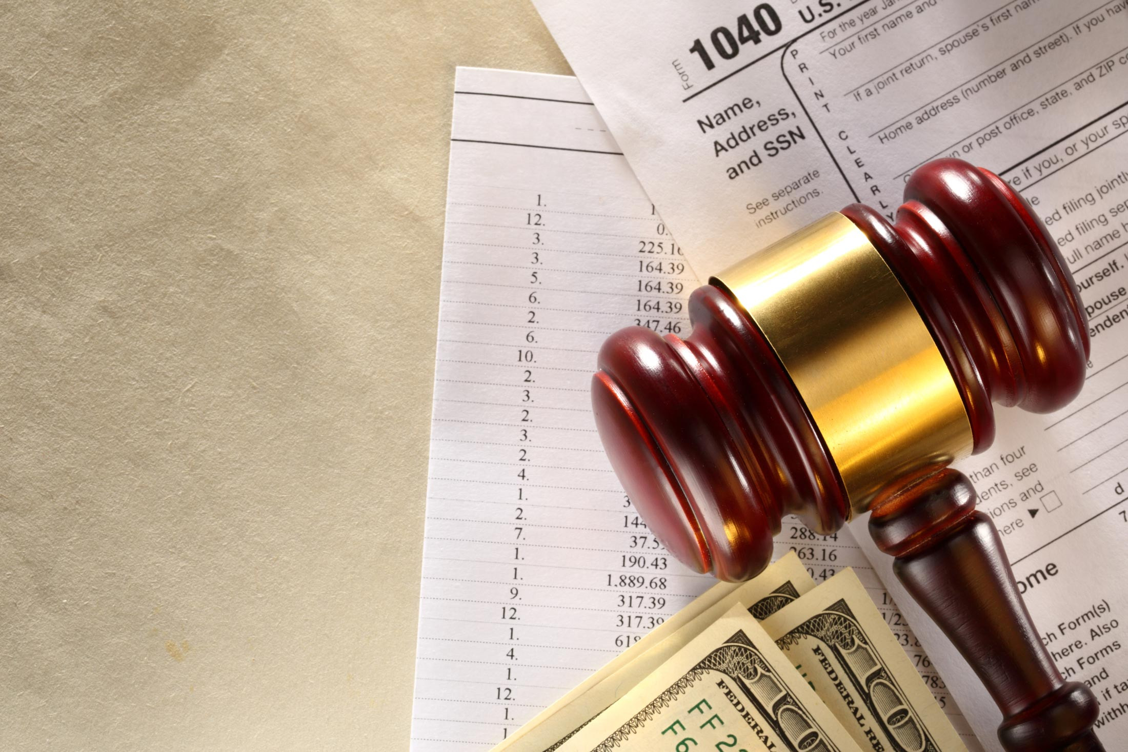 judge's gavel on the tax form with money