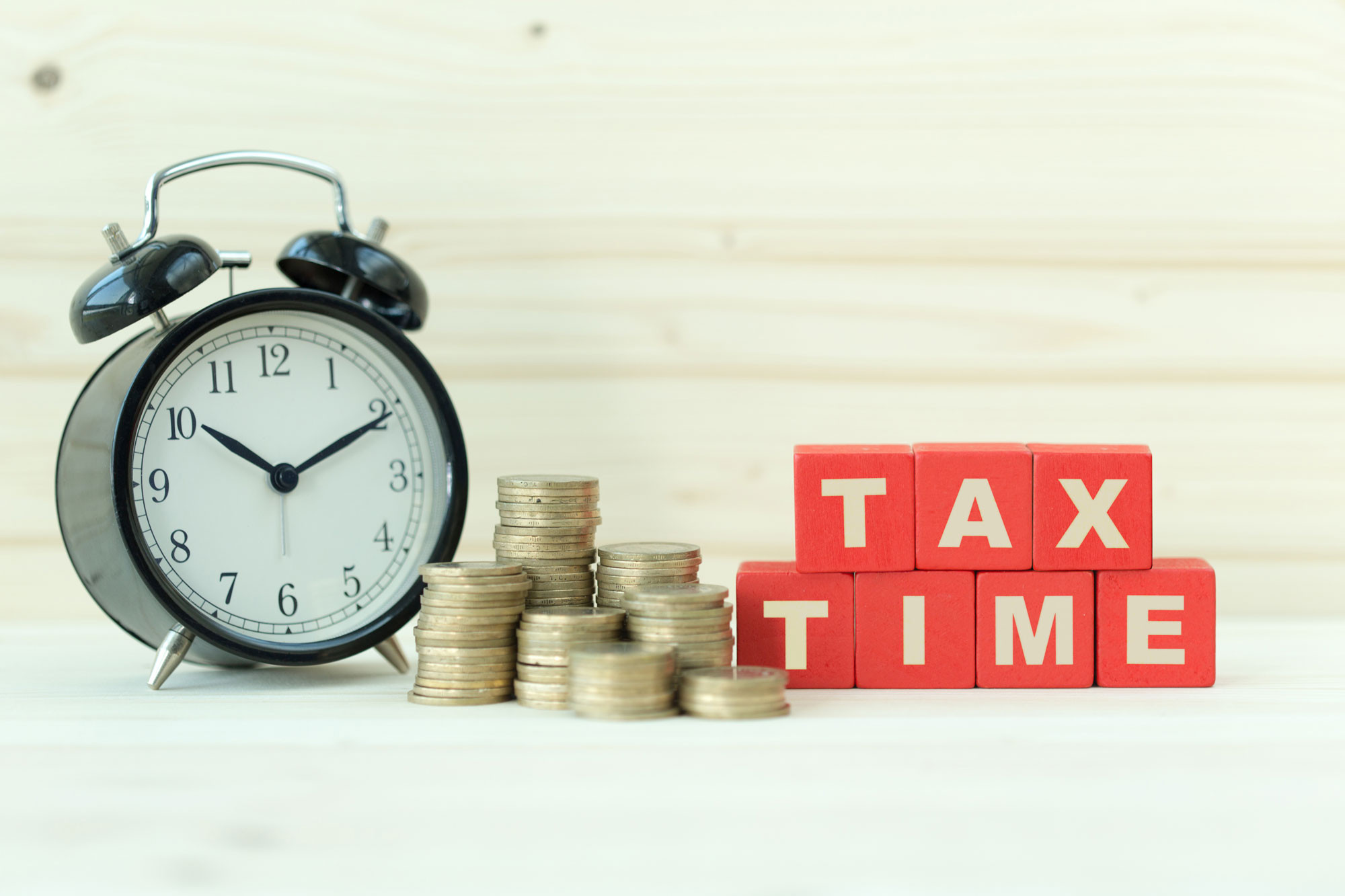 tax time blocks with alarm clock and coins