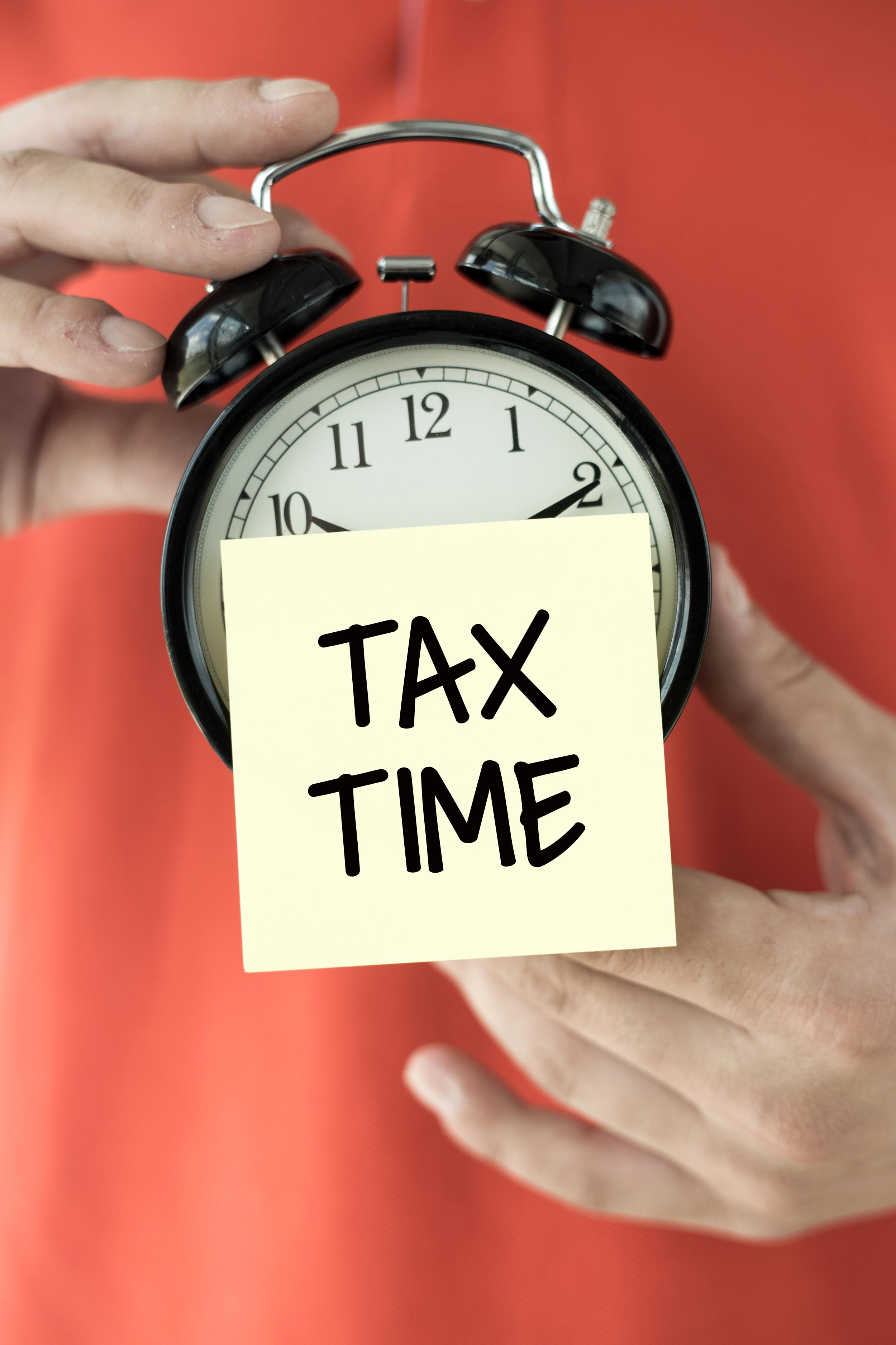 alarm clock holding person tax time