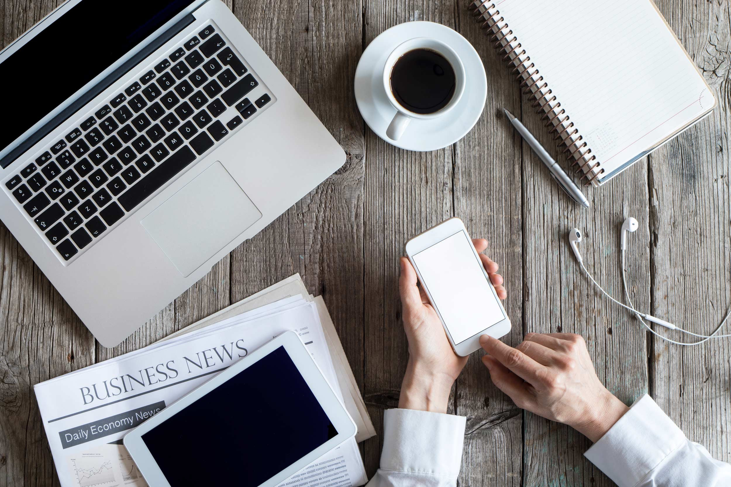 using phone with computer, coffee, notebook and tablet on business technology