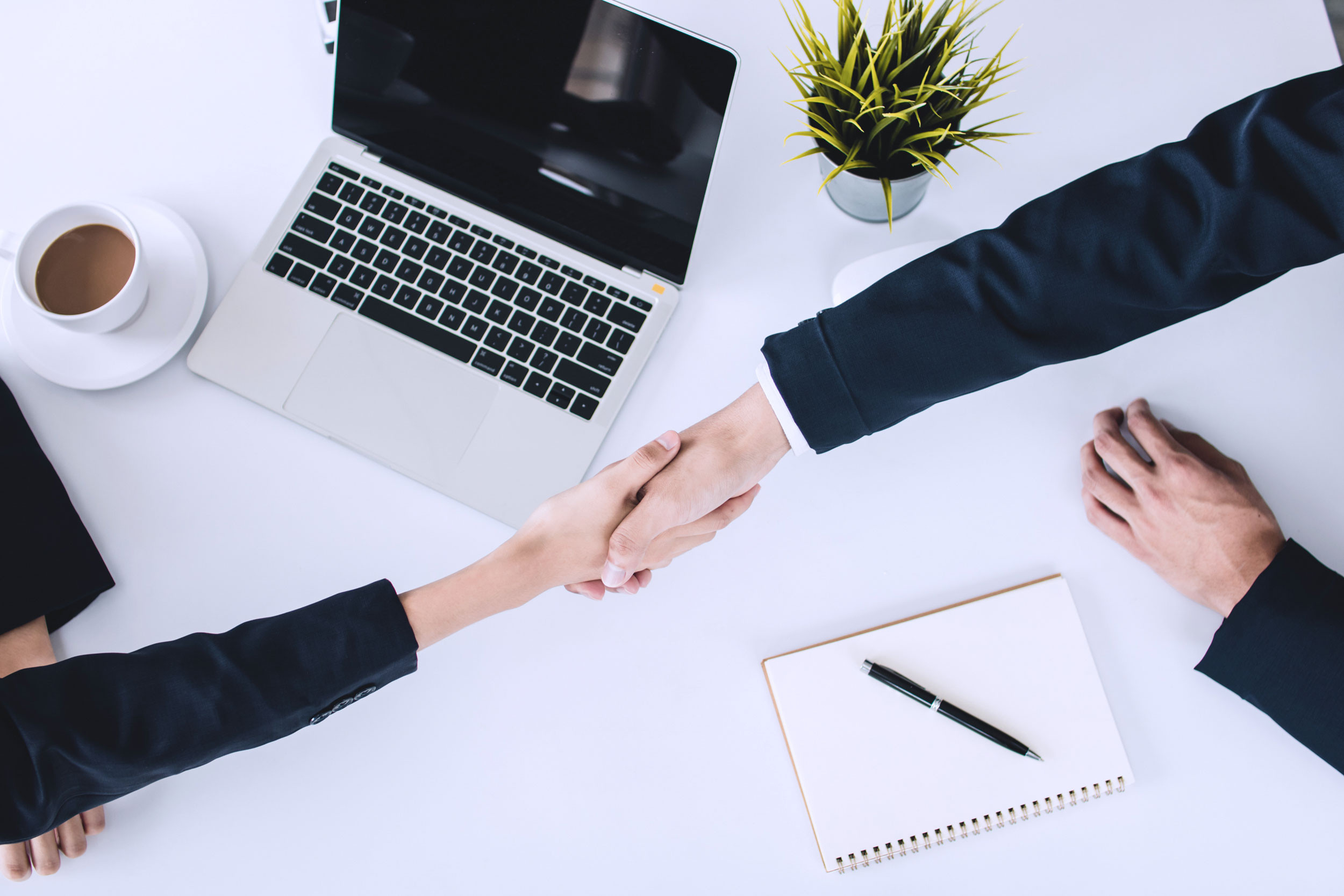 welcome handshake of two business hands at the desk